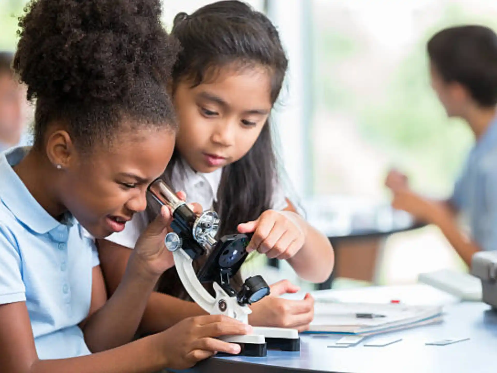 a few children looking at a microscope