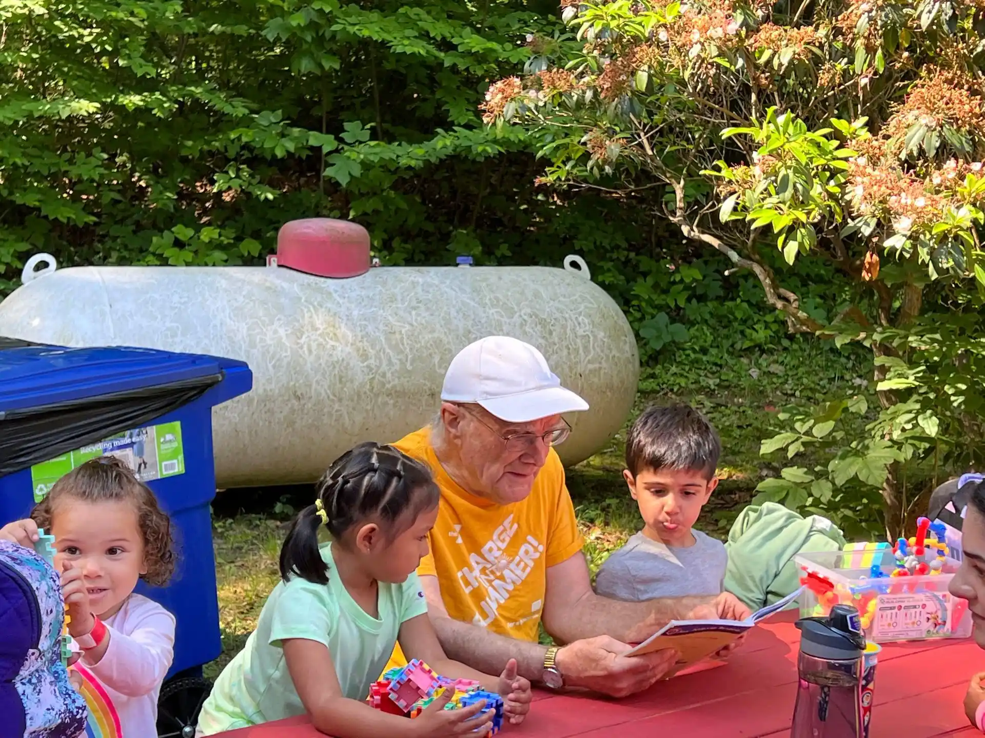 a person and children sitting at a table outside