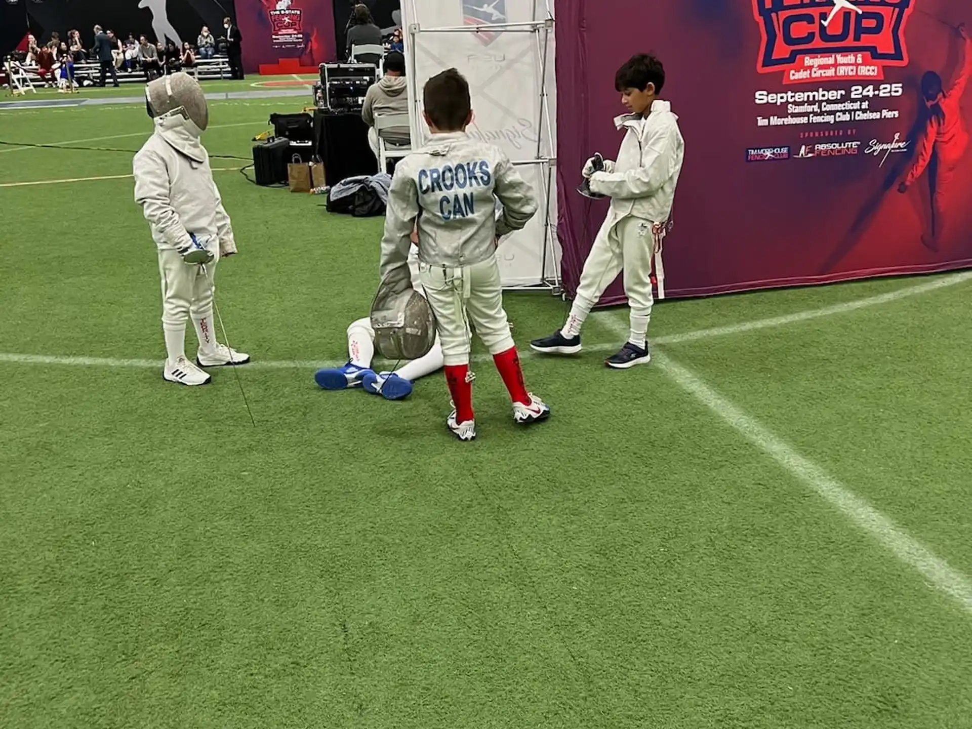a group of kids in white uniforms on a field