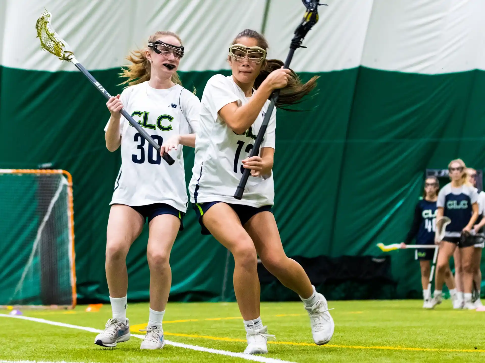 women playing lacrosse on a field