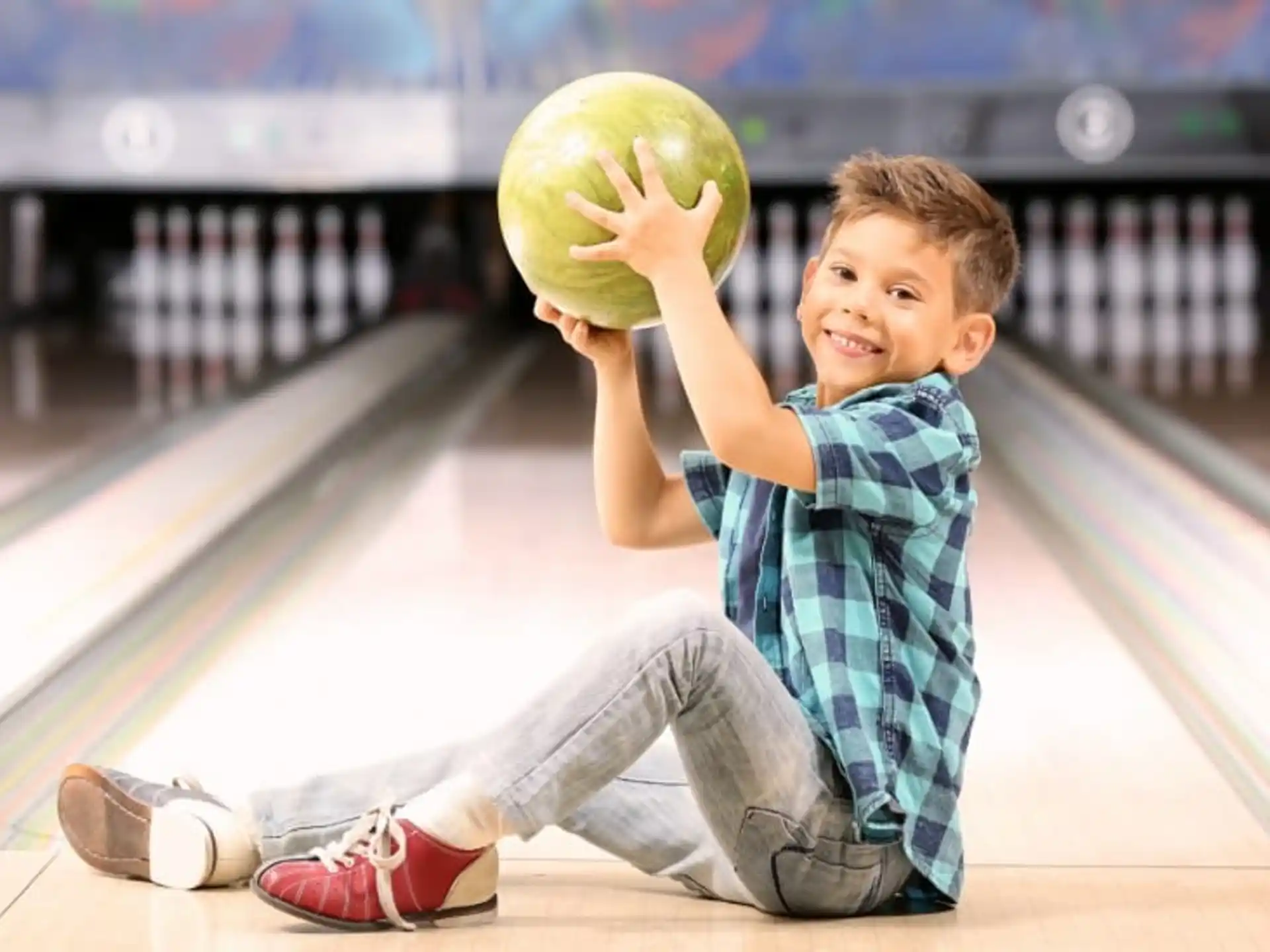 a boy holding a bowling ball