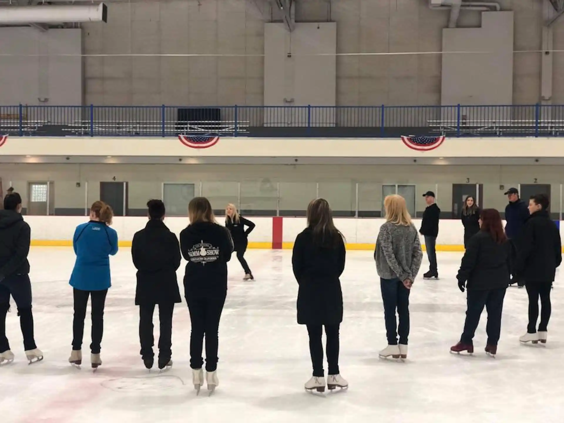a group of people standing in a large room with a large white wall