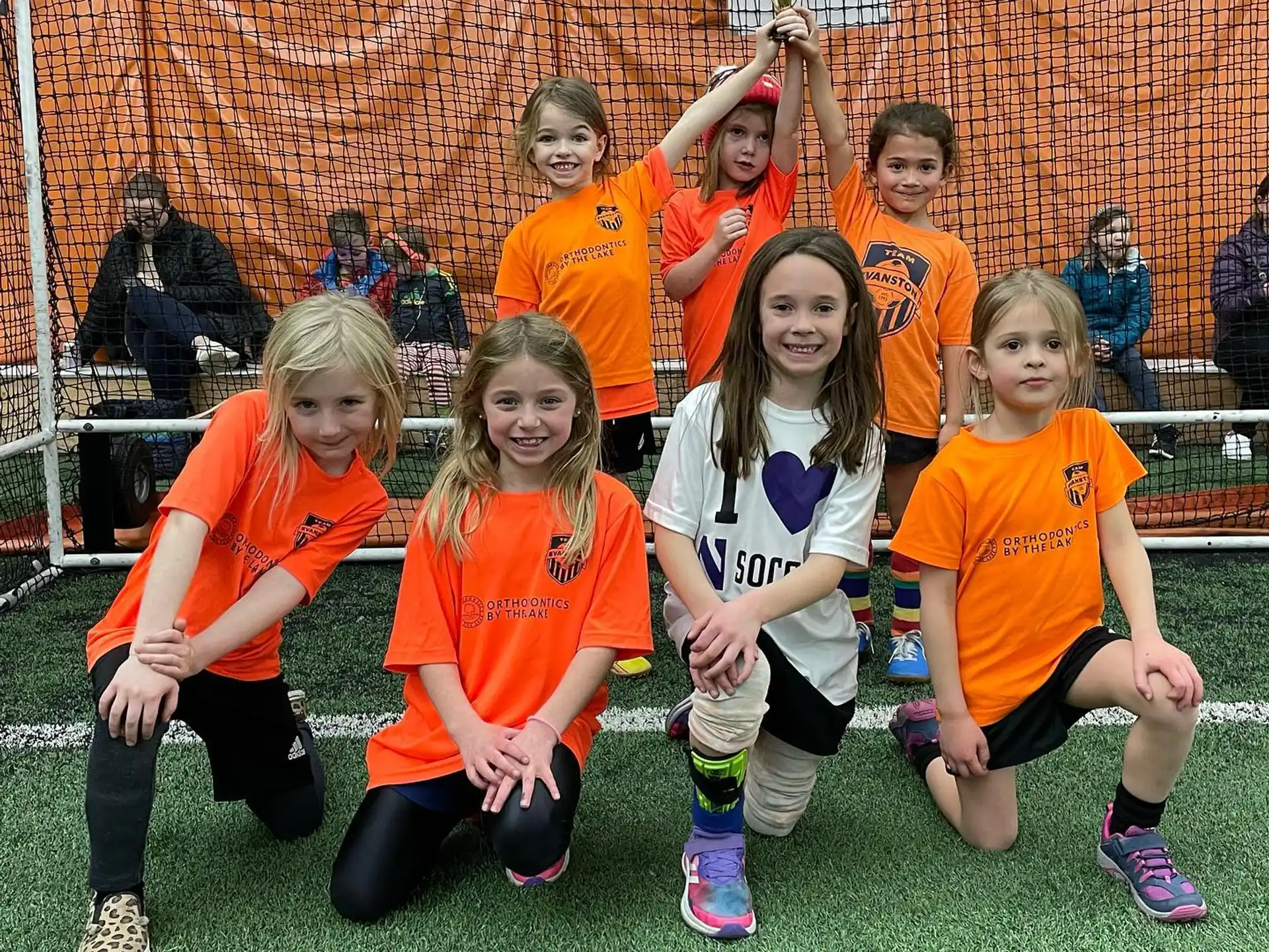 a group of girls in orange shirts