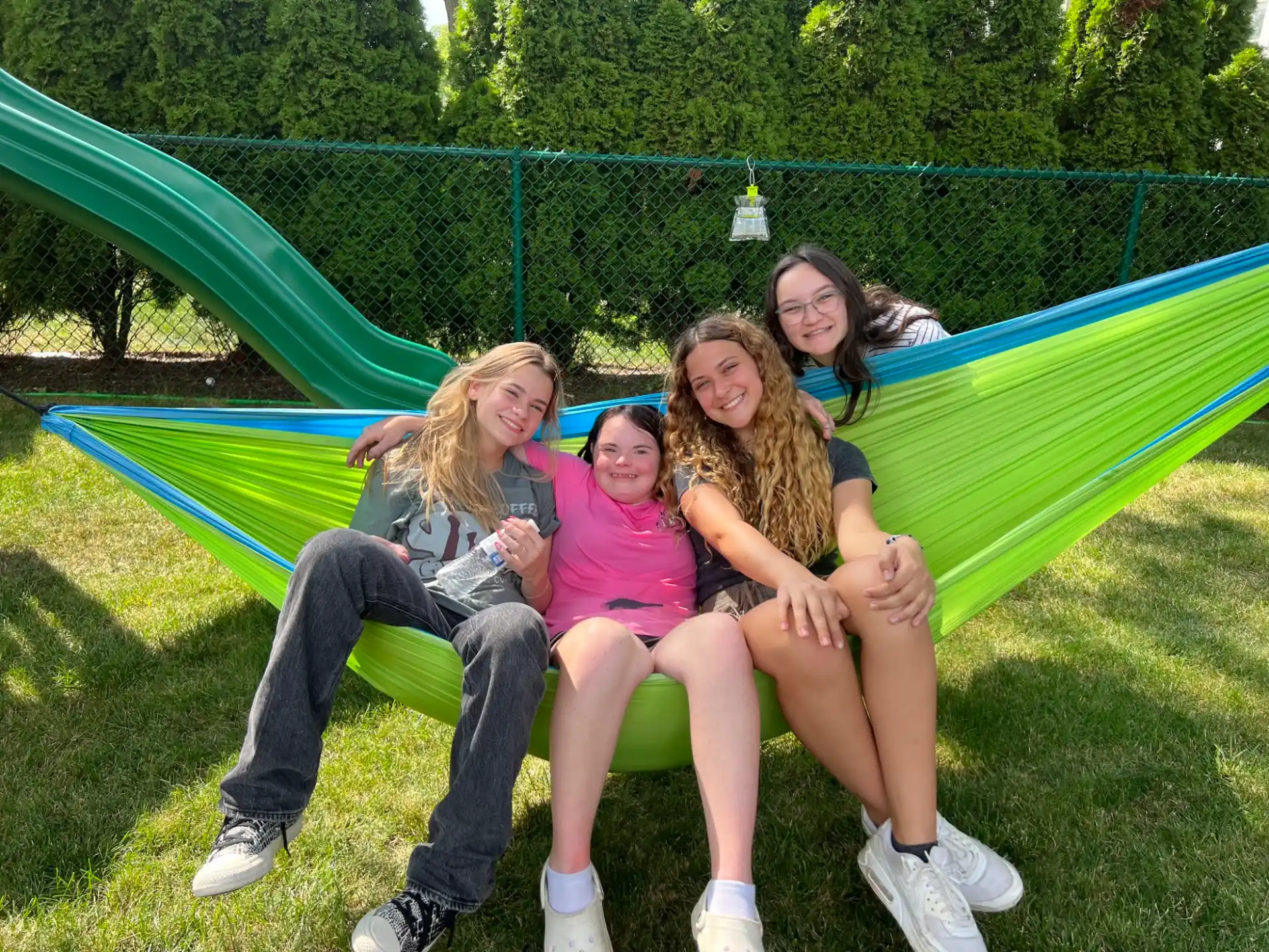 a group of women sitting on a bench in a park