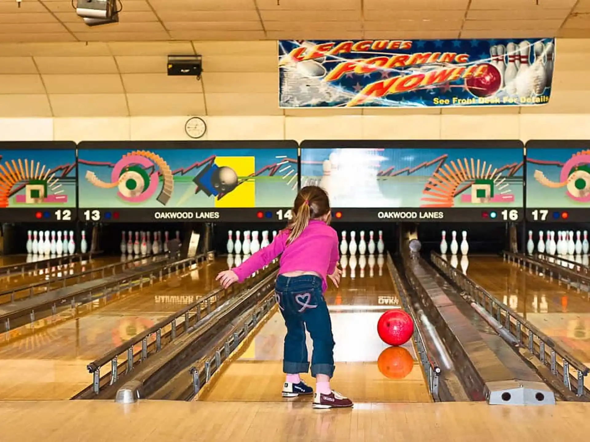 a girl bowling in a bowling alley