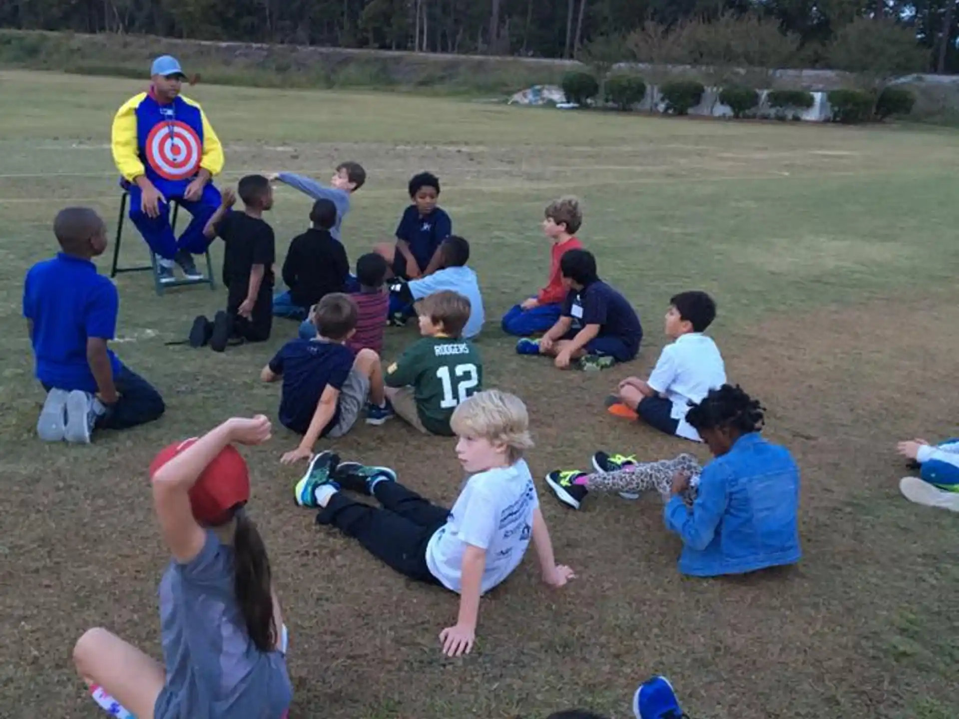 a group of people sitting on the grass