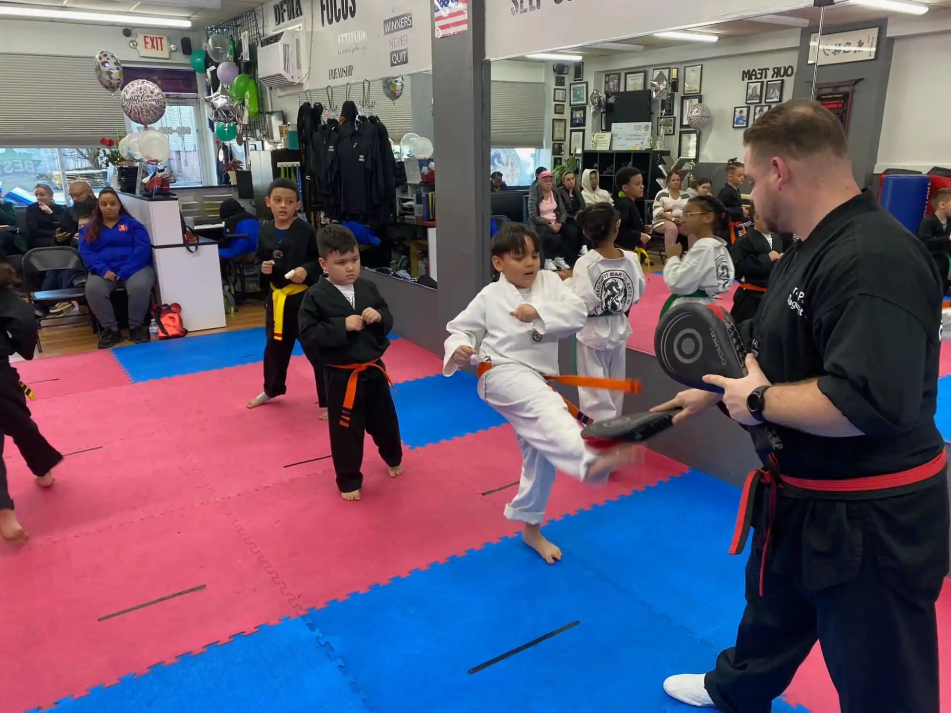 a person and a group of children in a karate class