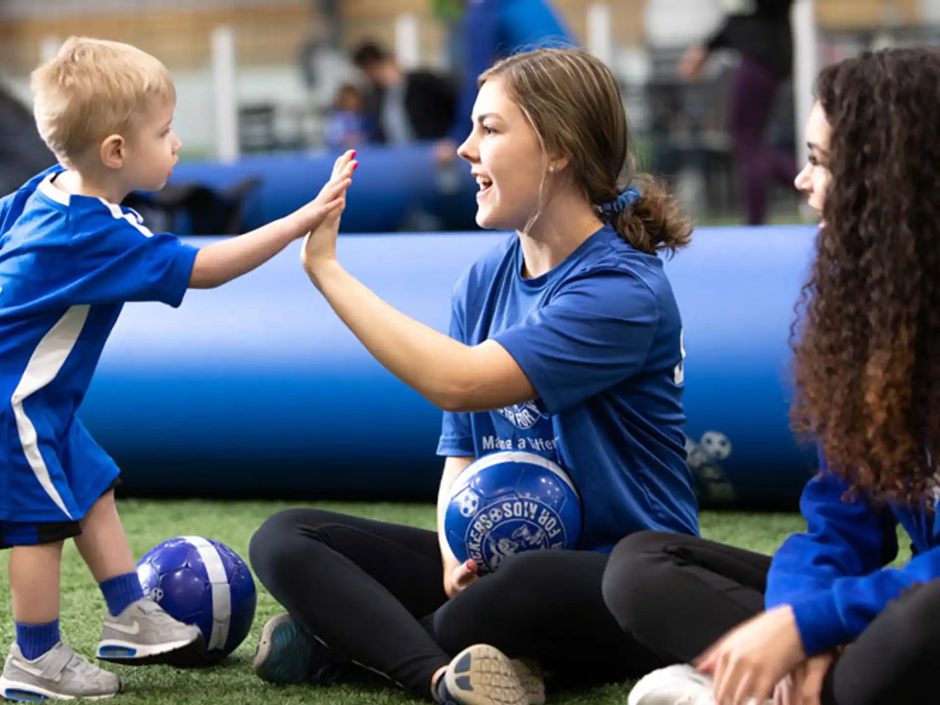 a woman and a couple of kids playing football