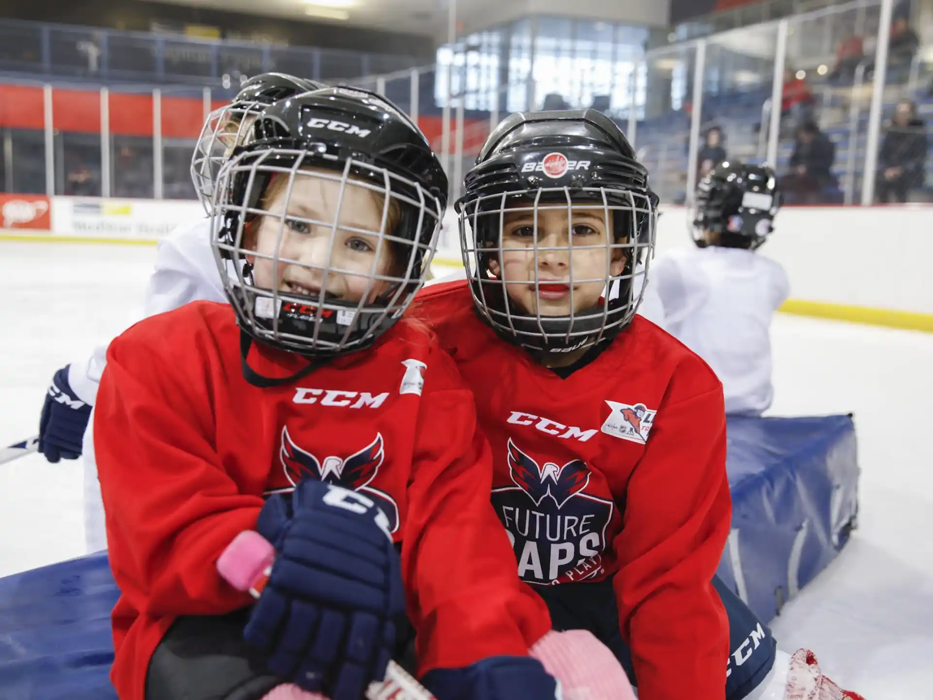 a couple of people wearing helmets and holding hockey sticks