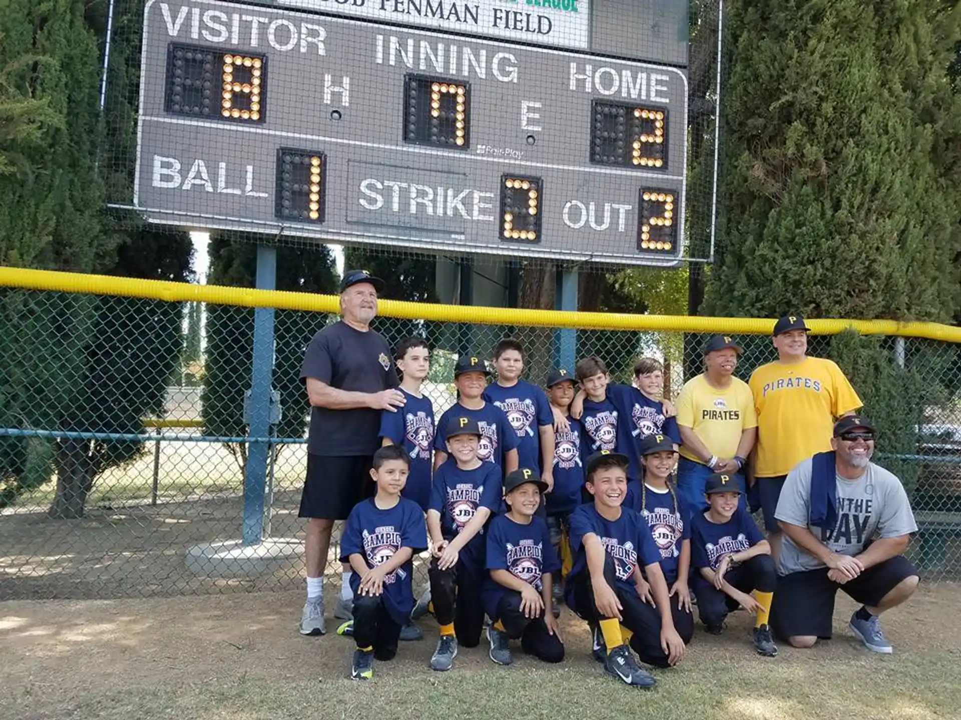 a group of people posing for a photo in front of a scoreboard