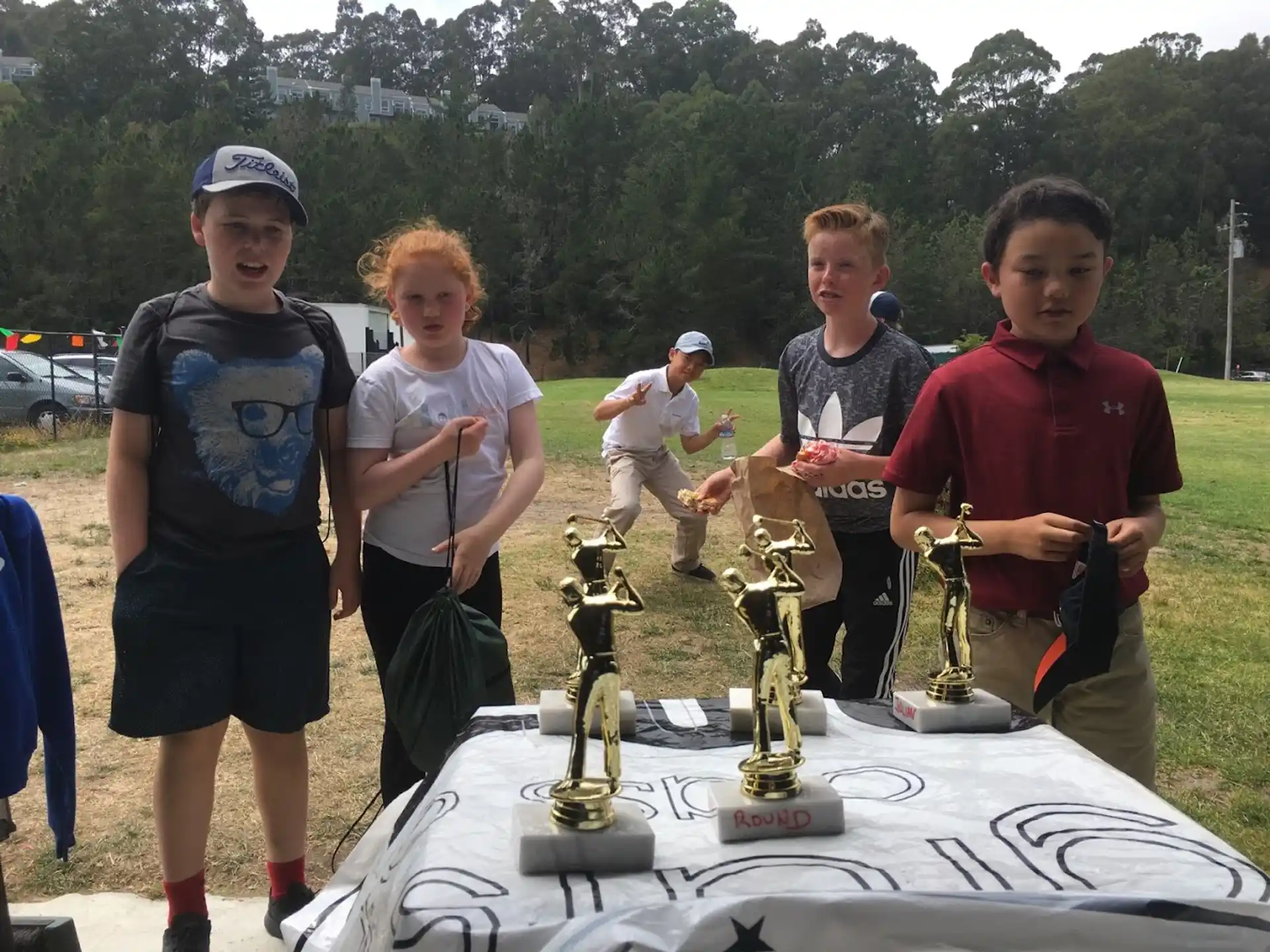 a group of people standing around a table with a trophy