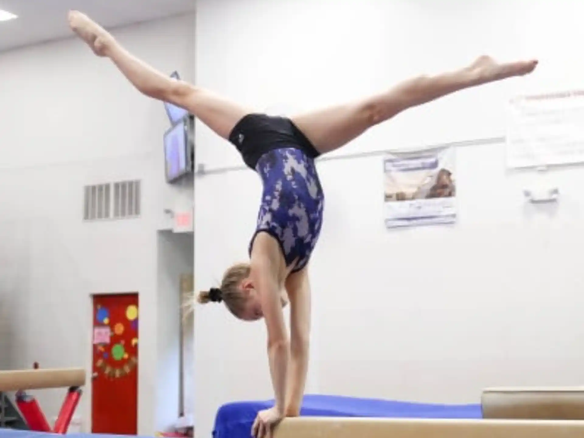 a person doing a handstand on a mat in a room