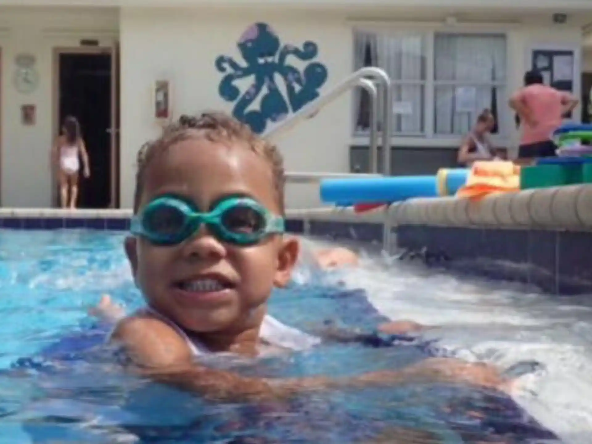 a boy in a pool wearing goggles