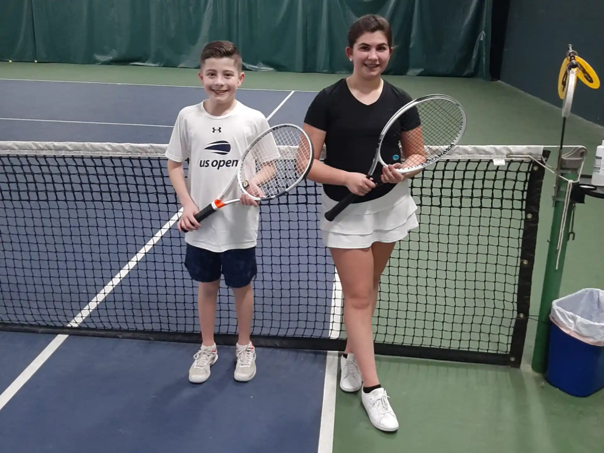 a couple of people holding tennis rackets on a court