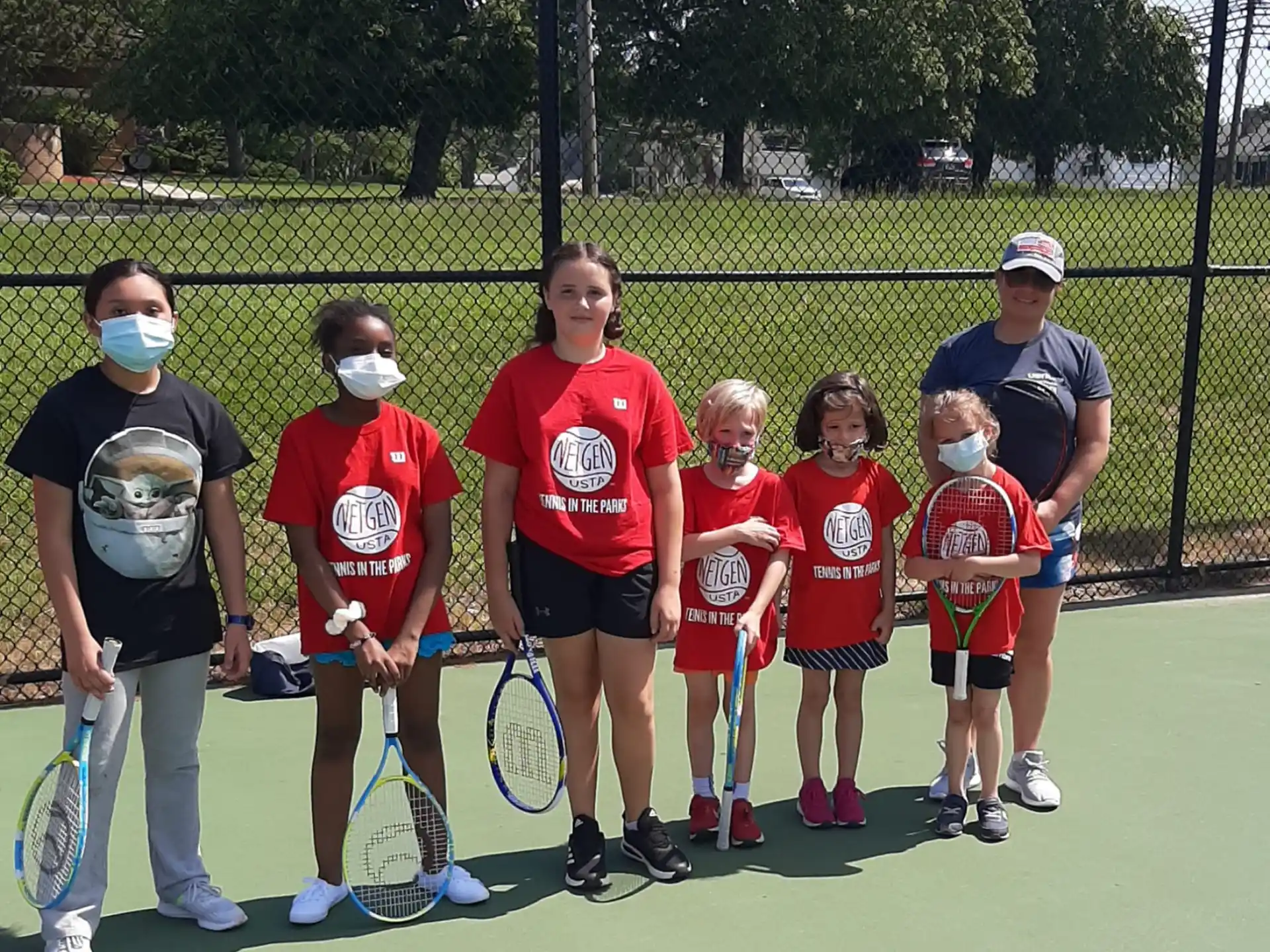 a group of kids holding tennis rackets