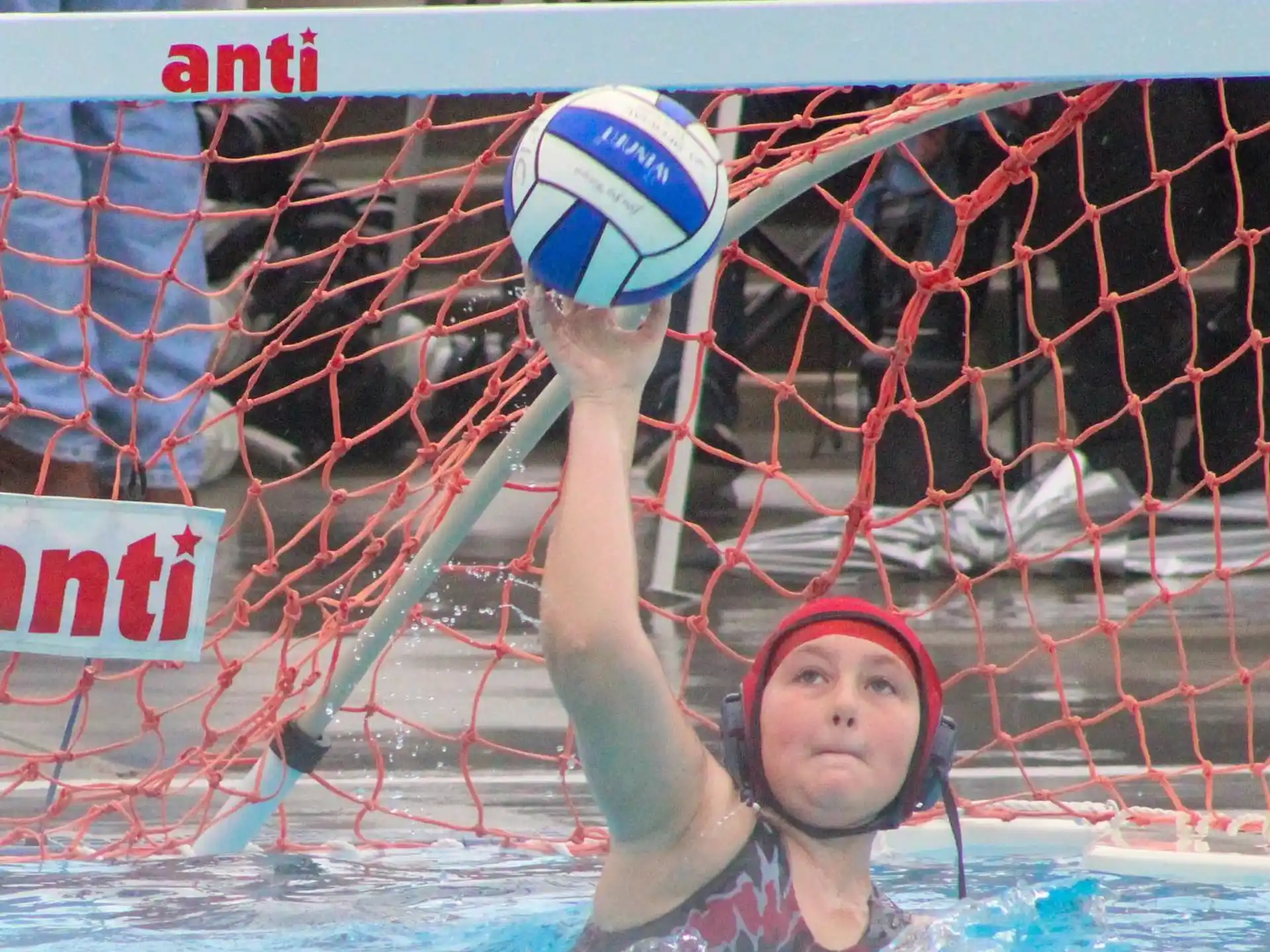 a person in a pool with a ball in the hand