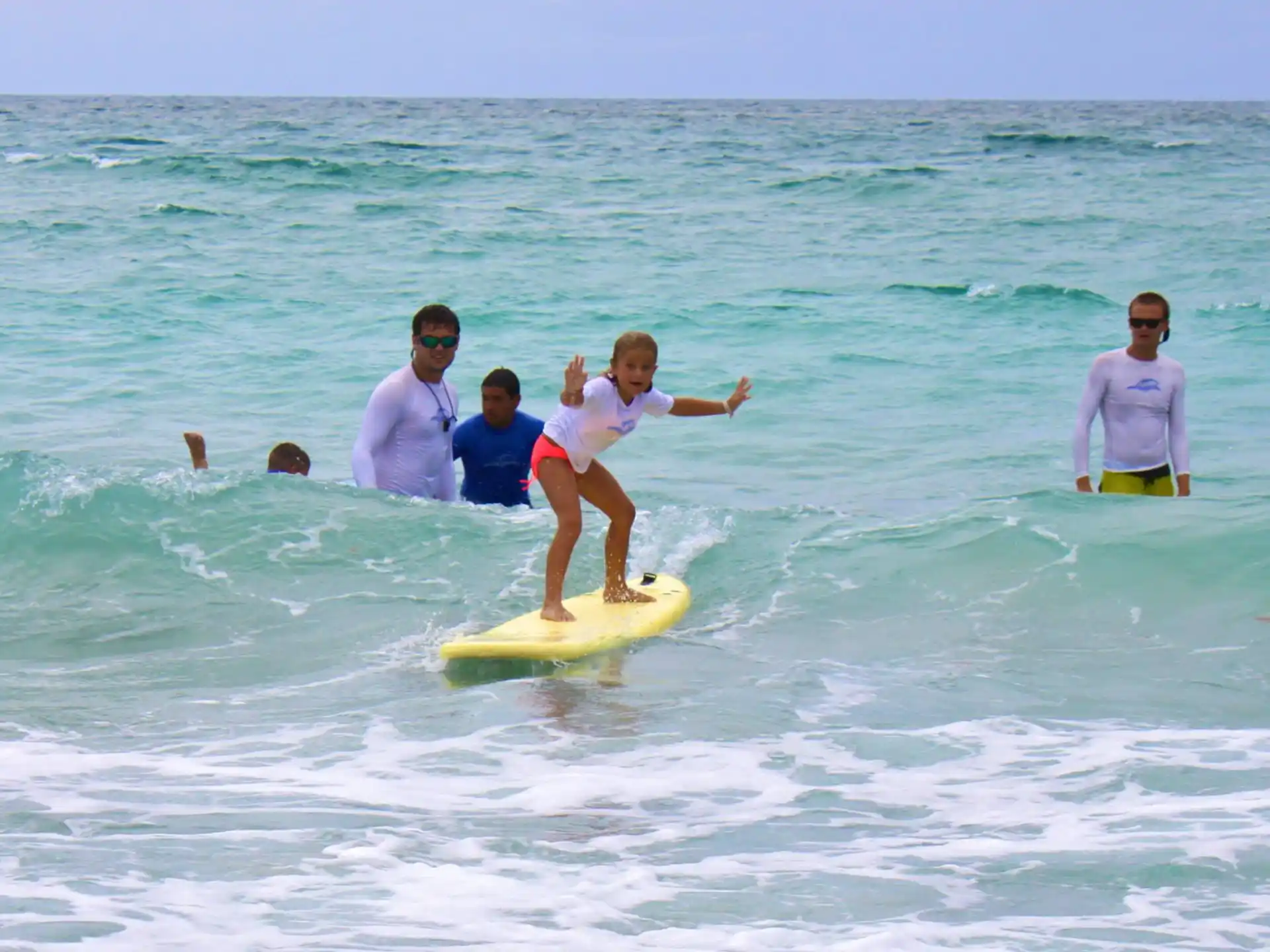 a group of people on a surfboard in the ocean