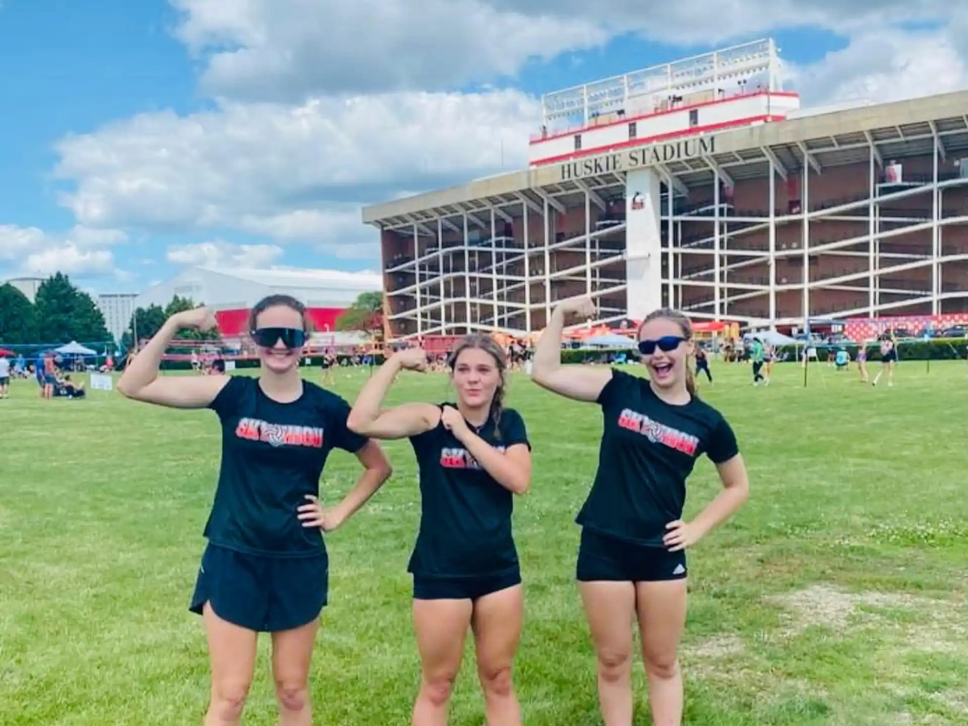 a group of women posing for a picture in front of a stadium