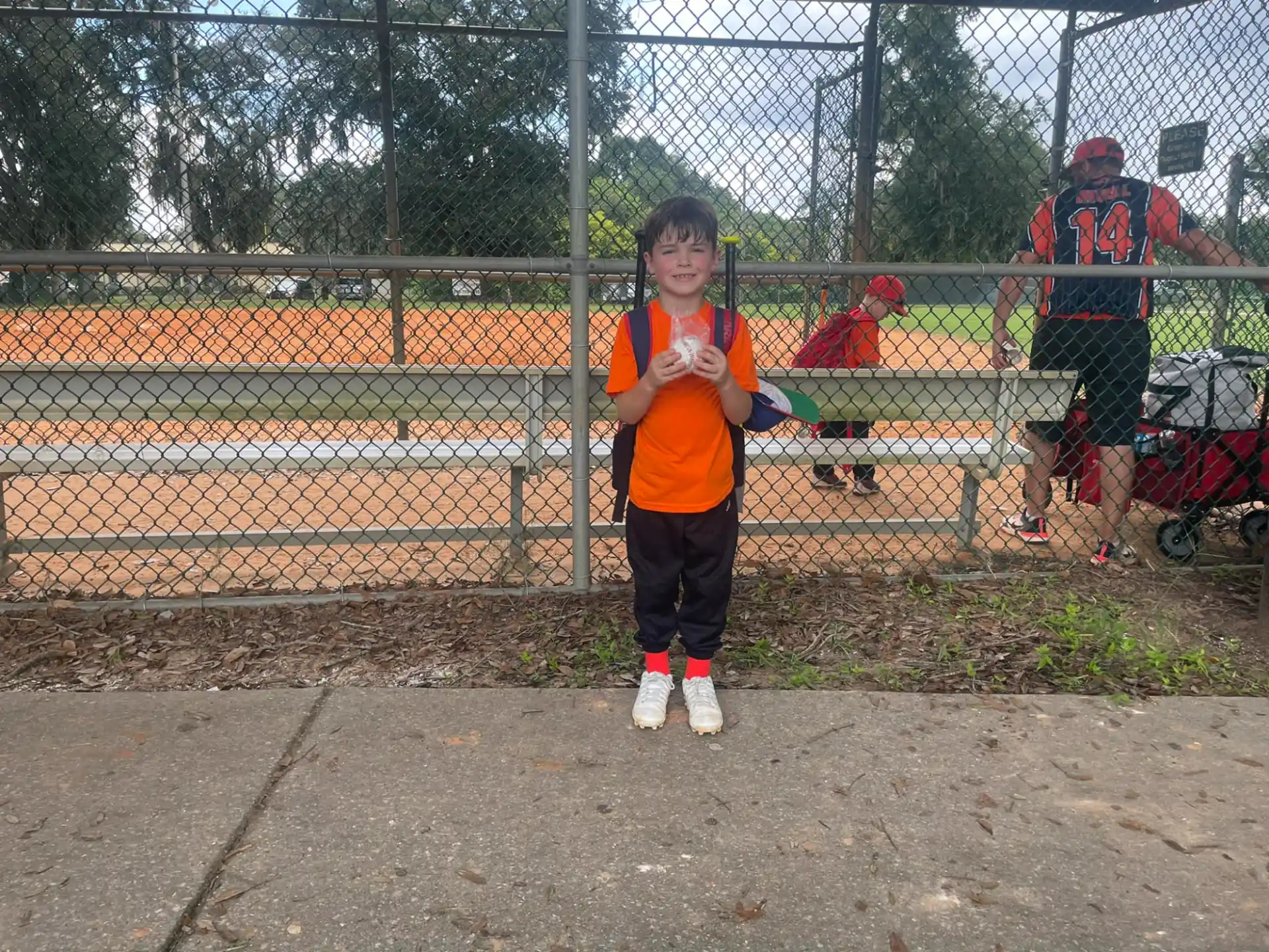 a boy standing in front of a fence