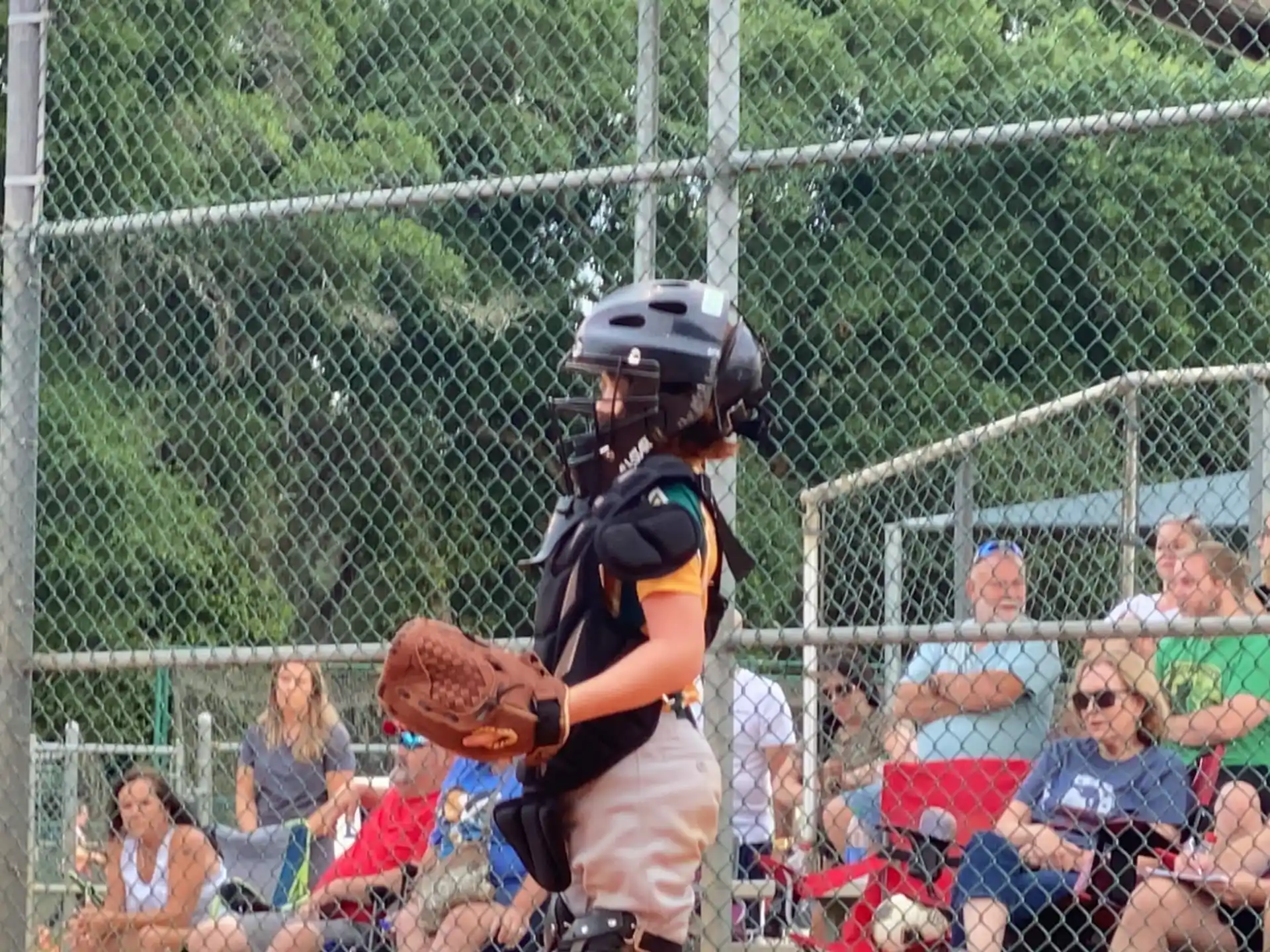 a kid in a baseball uniform prepares to throw a baseball