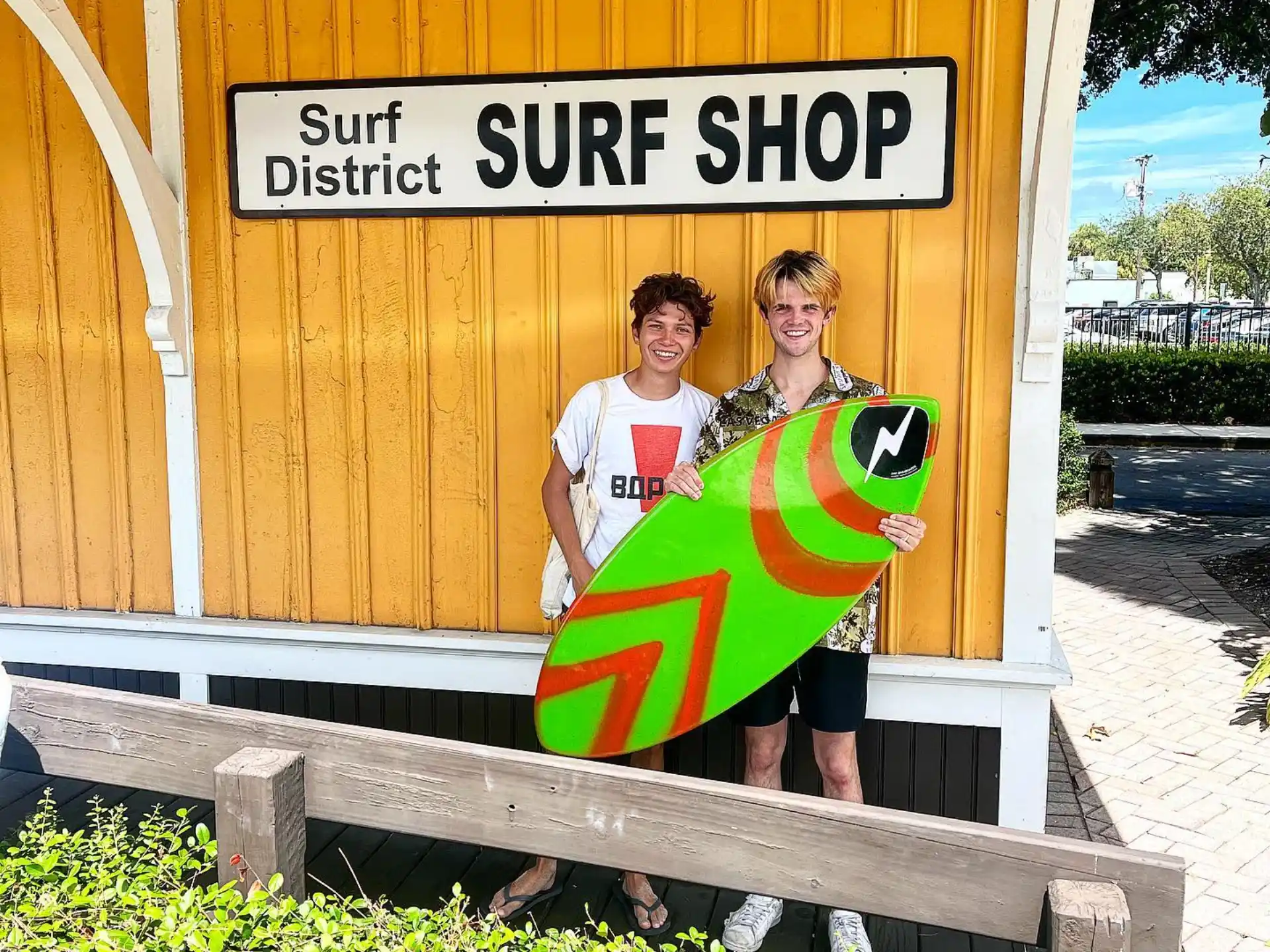 a couple of men holding surfboards