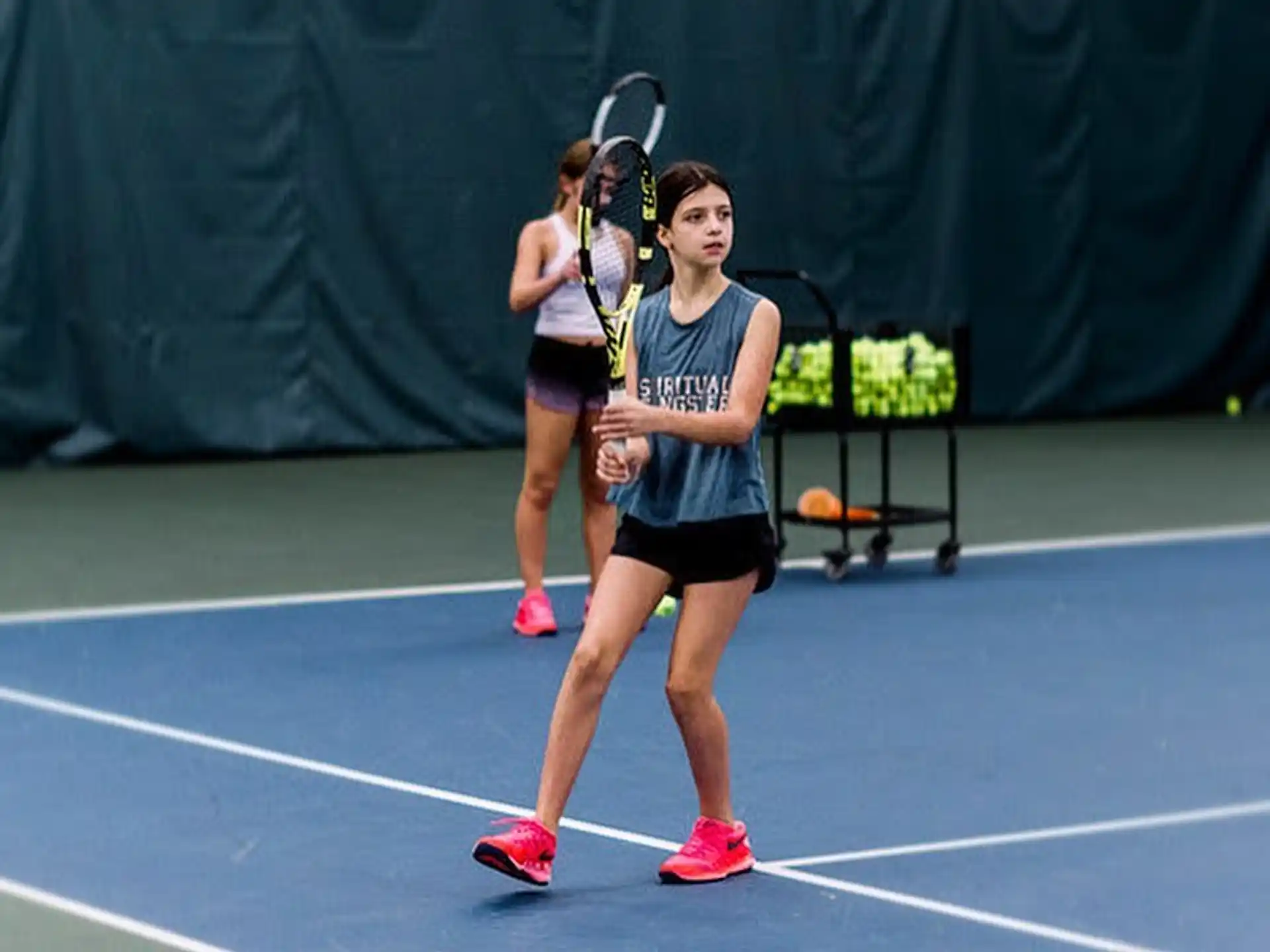 a couple of women holding tennis rackets on a tennis court