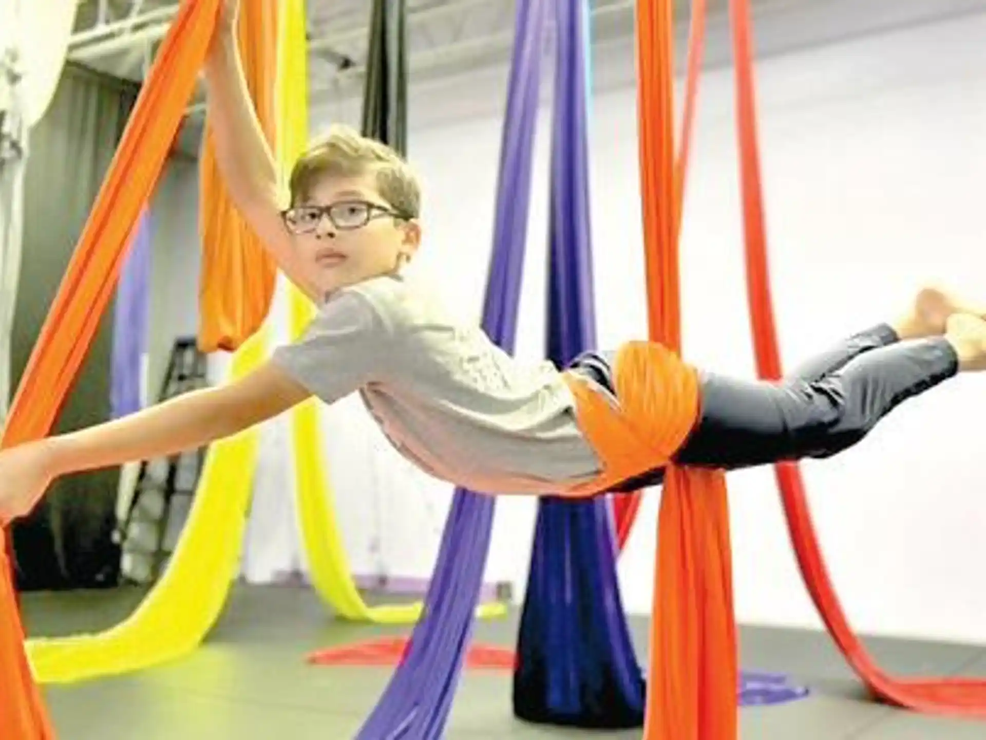 a boy jumping over a bar
