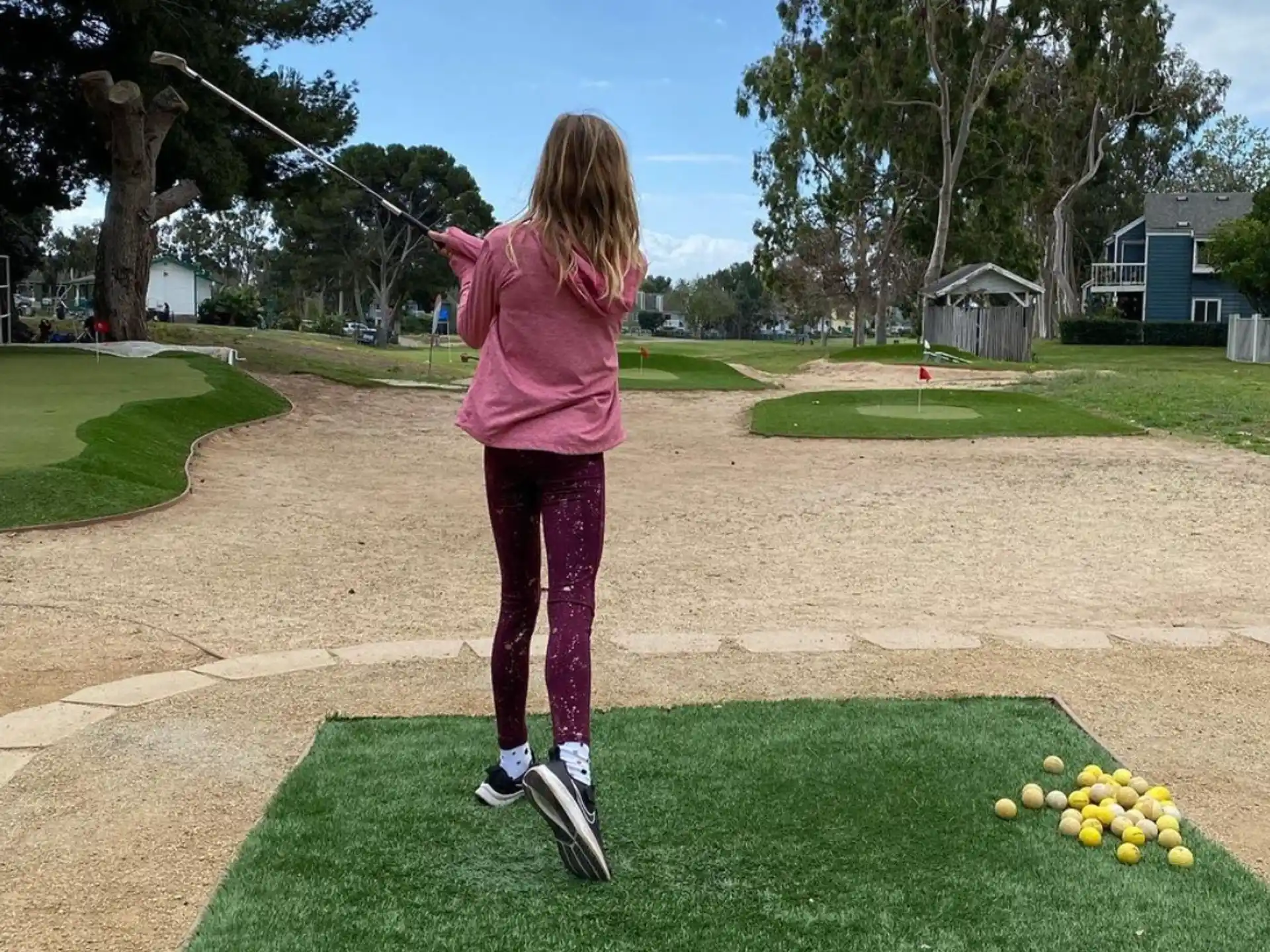 a girl swinging a golf club