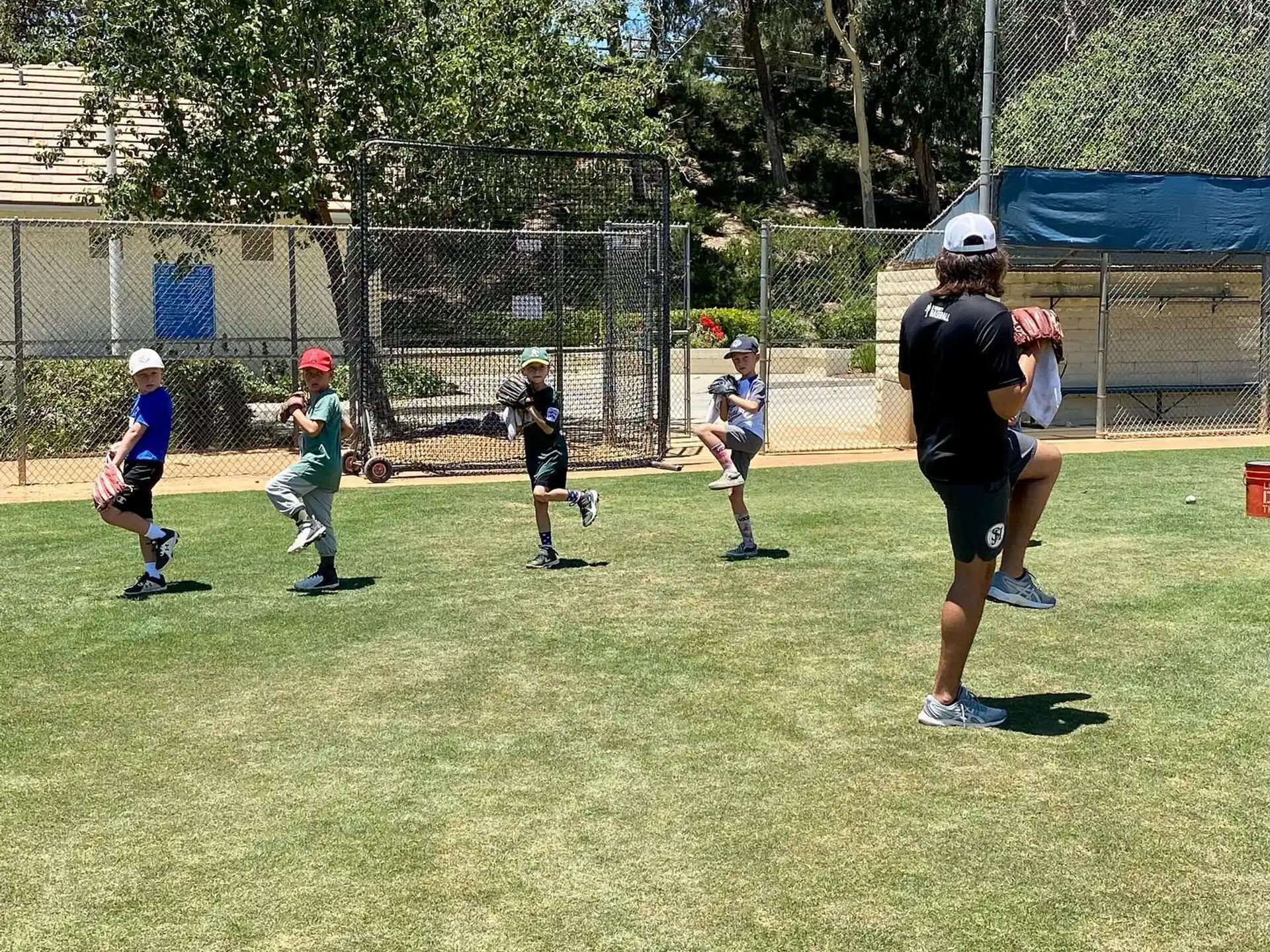 a person playing baseball with kids