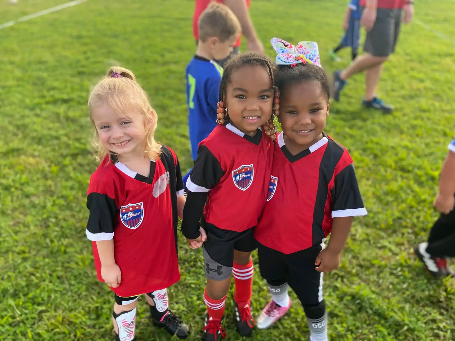 a group of children in red and blue uniforms on a field