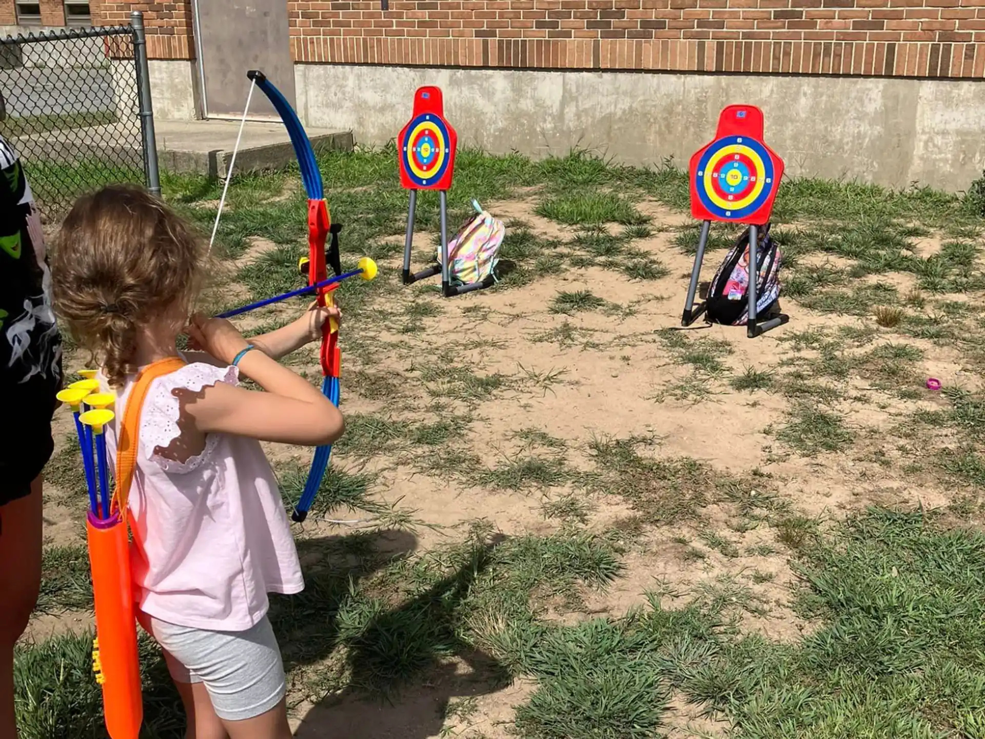a group of children playing with toy swords outside