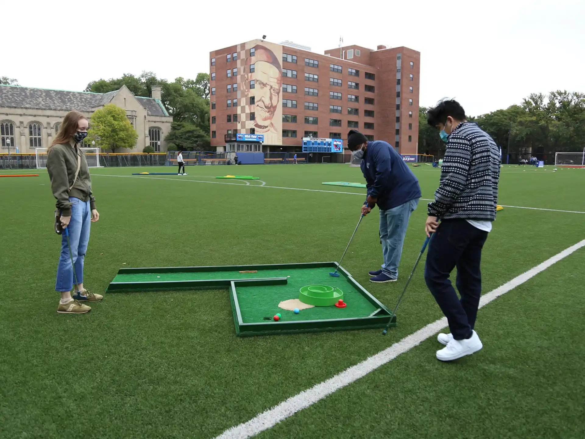 a group of people playing ping pong in a field