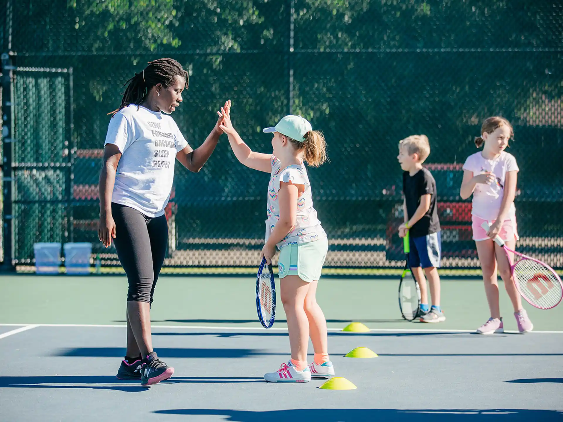 a woman and kids playing tennis