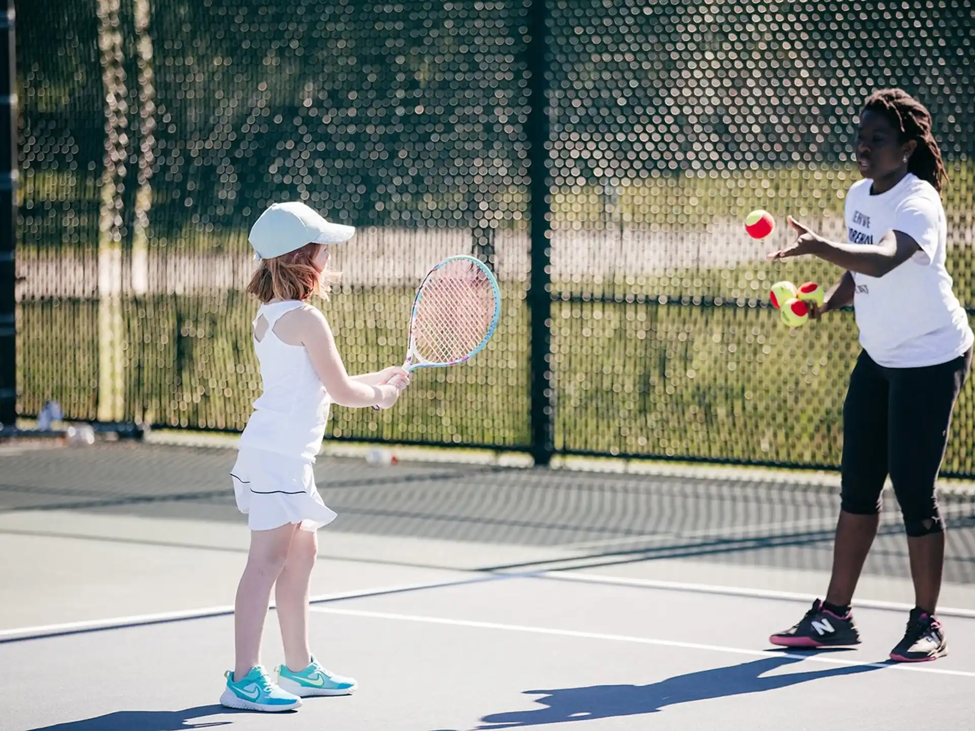 girls playing tennis on court