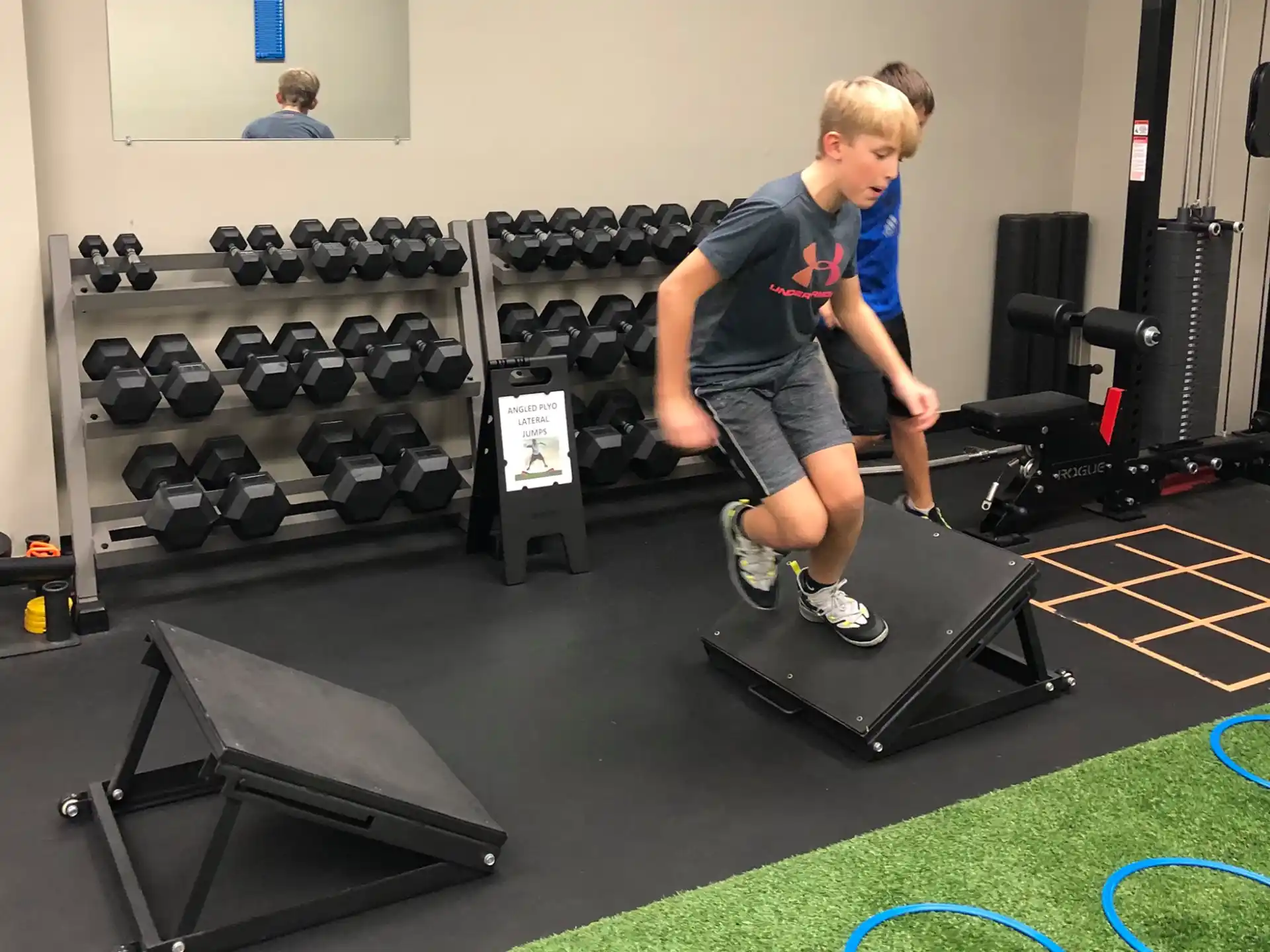 a boy standing on a weight bar
