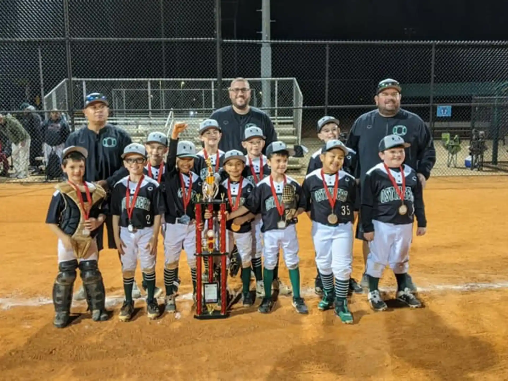 a group of kids posing for a photo on a baseball field