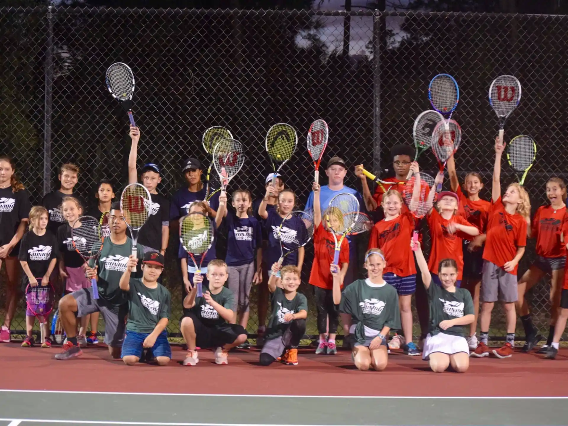 a group of kids holding tennis rackets