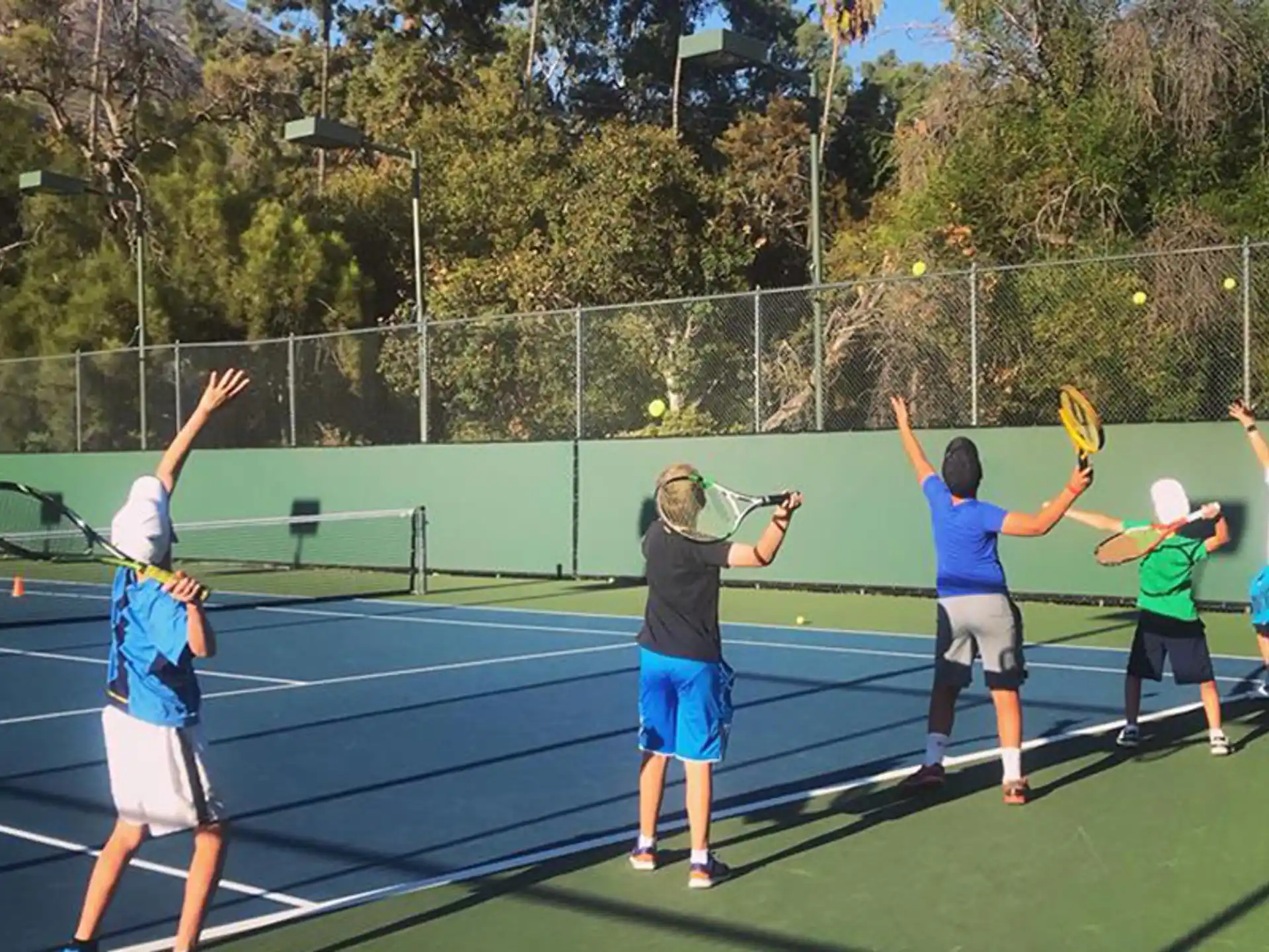 a group of kids playing tennis