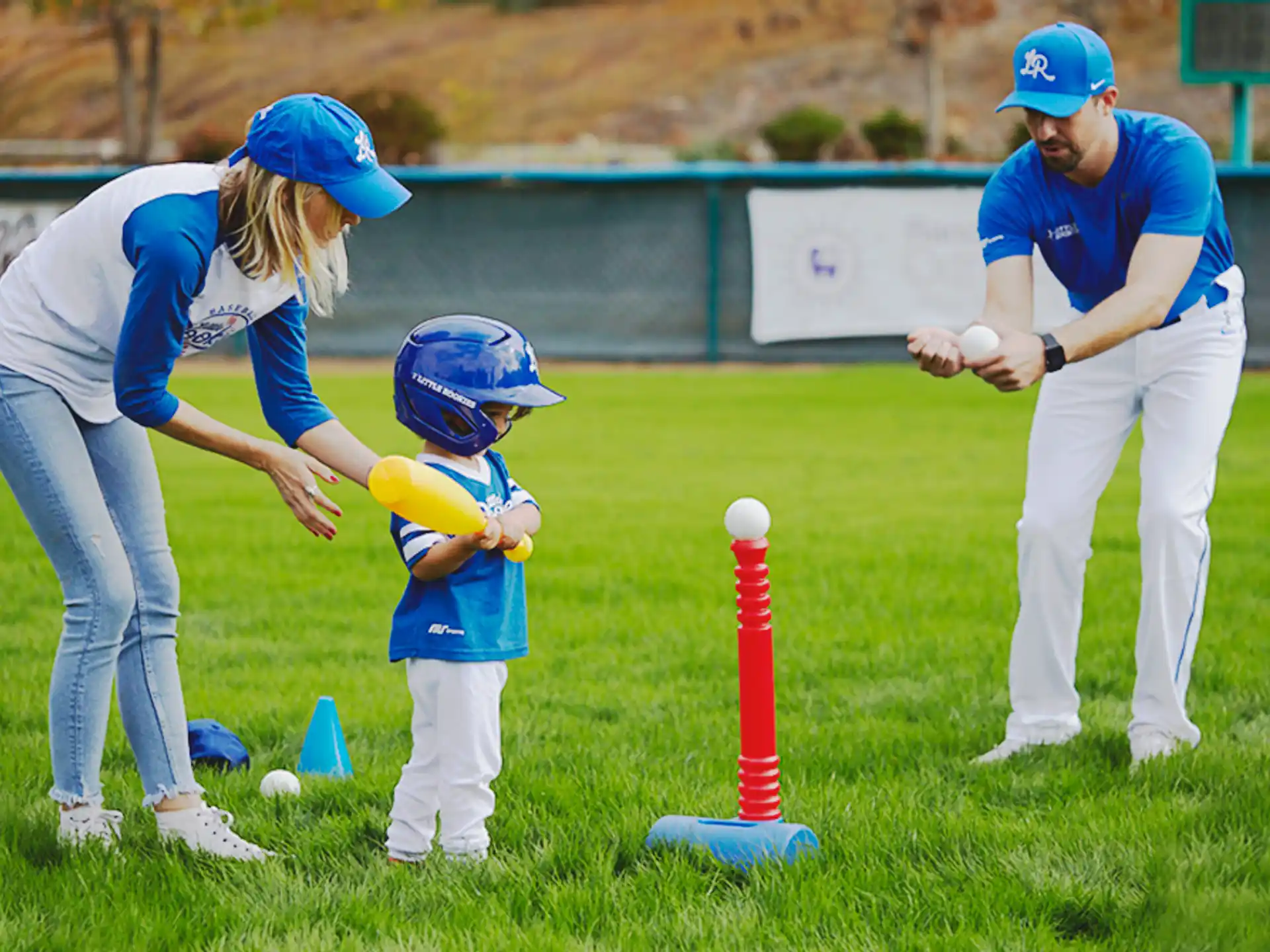 a person and a child playing tee ball