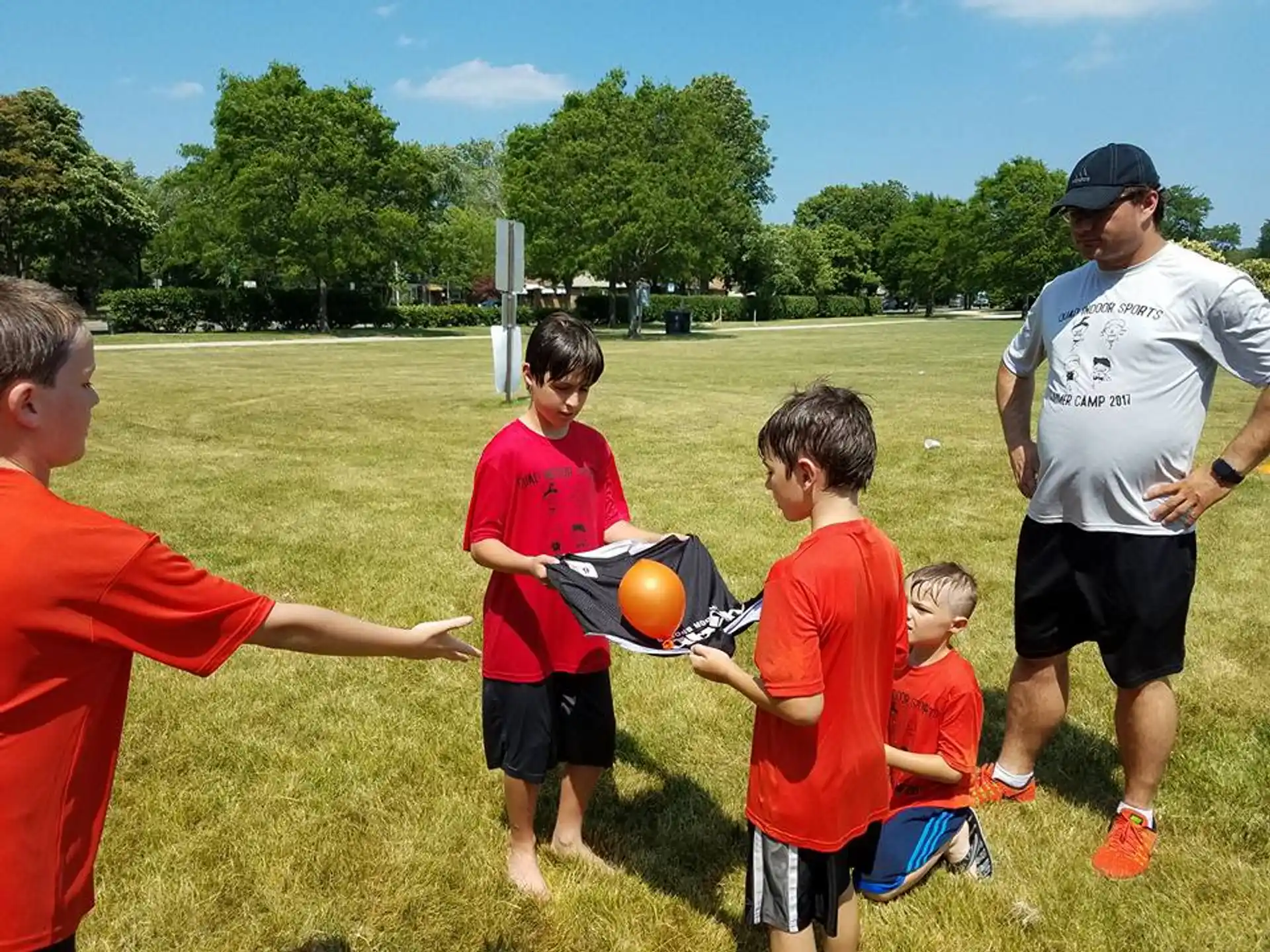 a group of people playing with a ball in a field