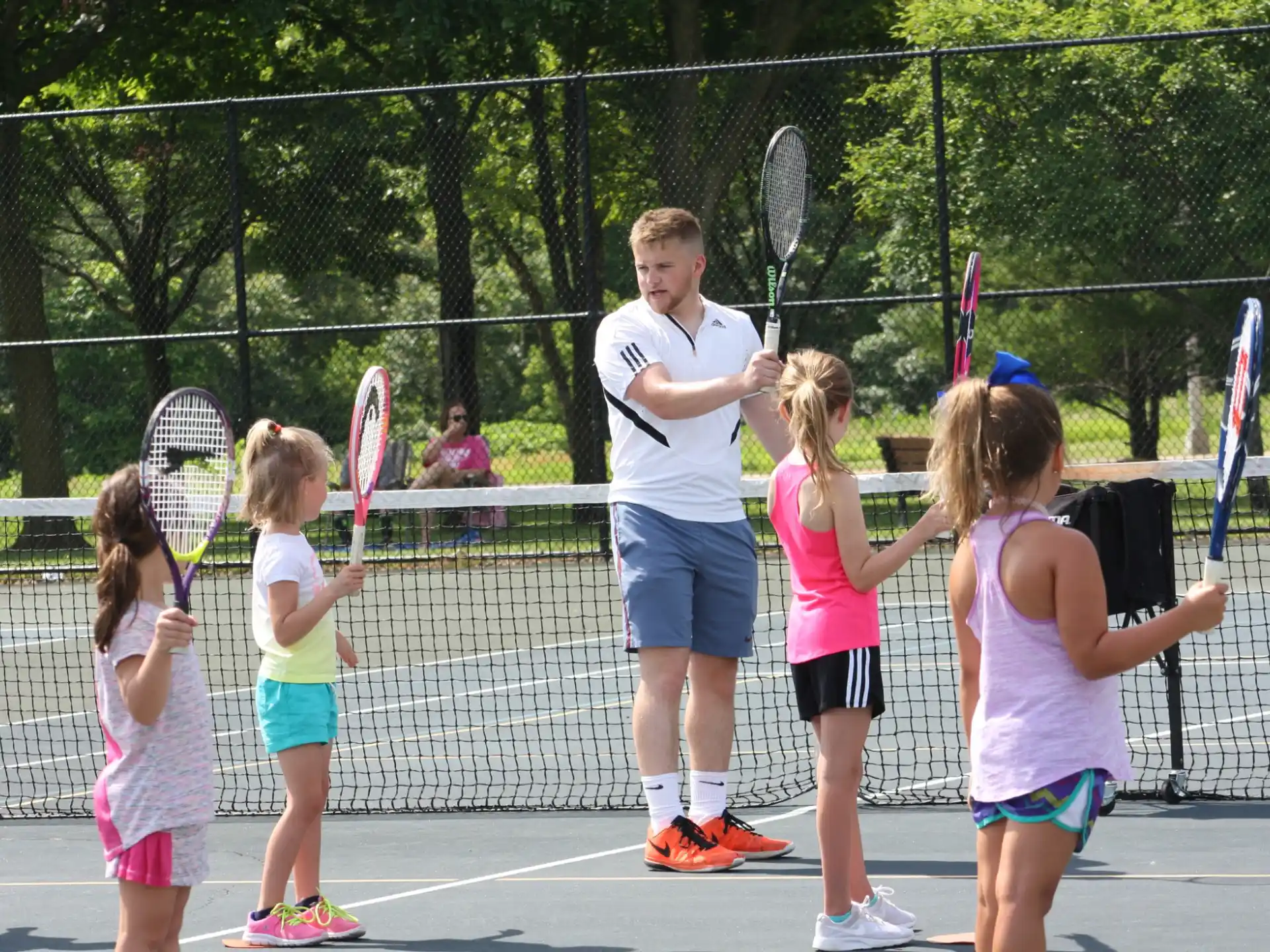 a group of kids holding tennis rackets