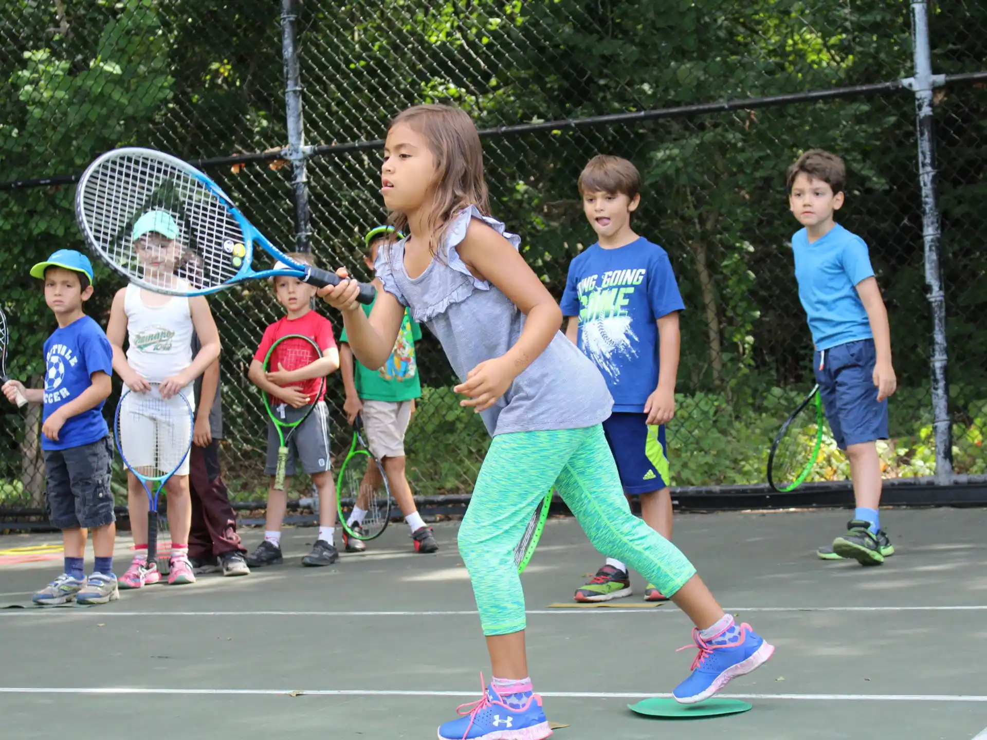 a group of kids playing tennis