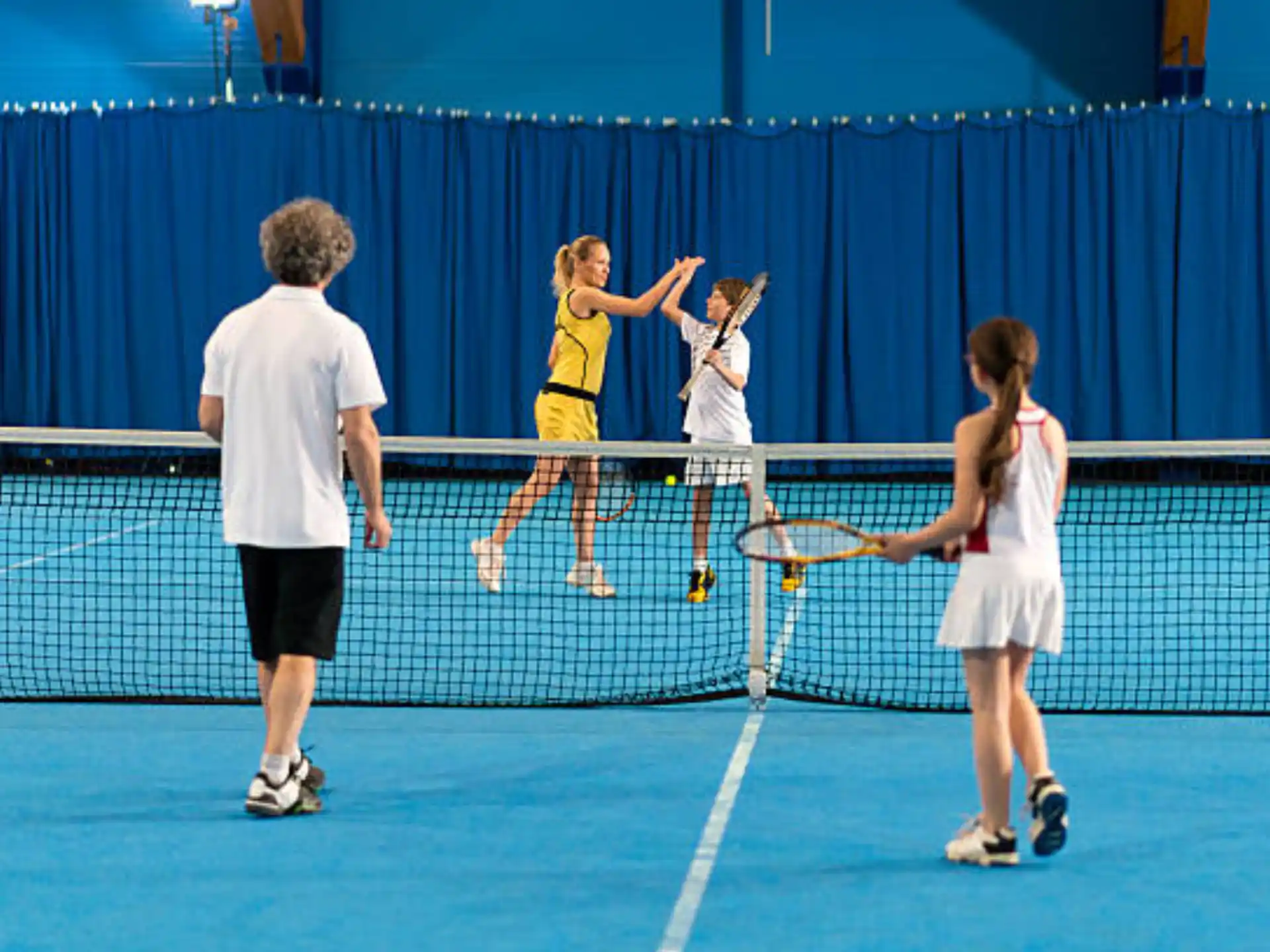 a group of people play tennis