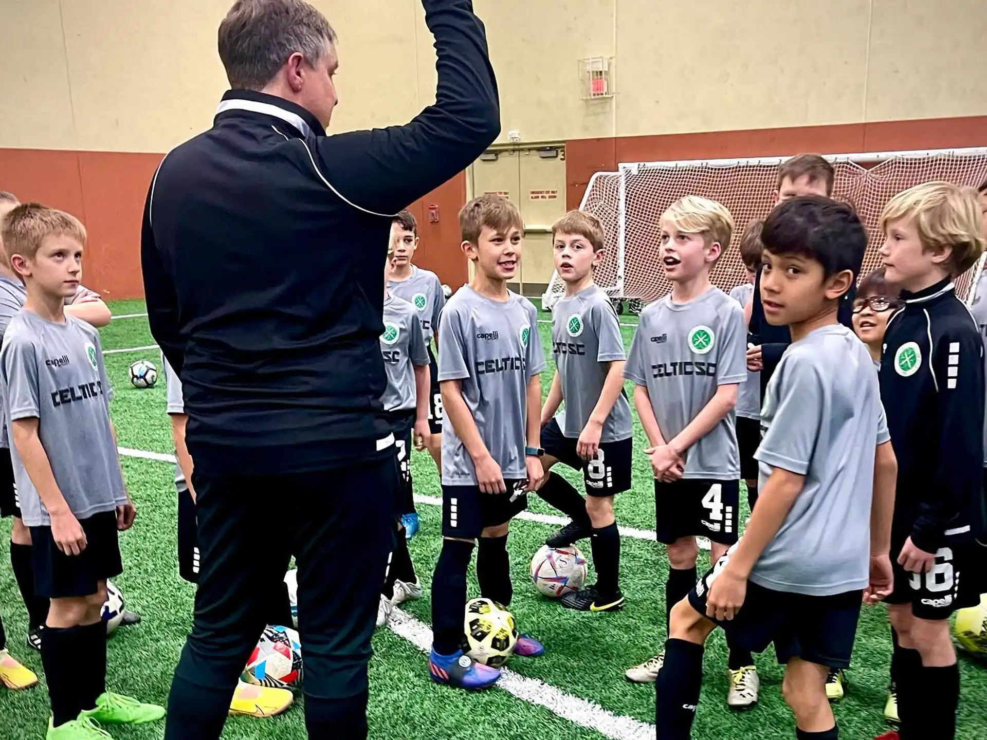 a person standing in front of a group of kids in a football field