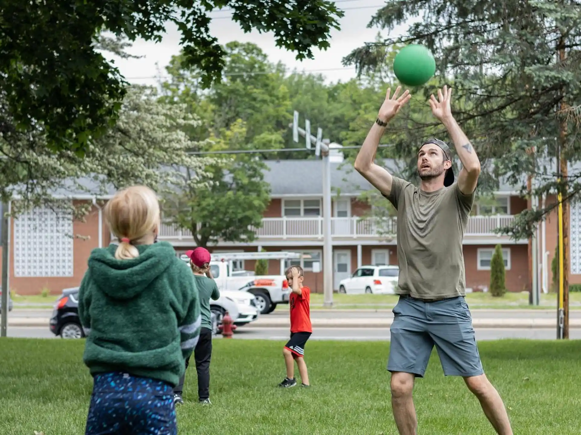 a man and a girl playing with a ball in a park