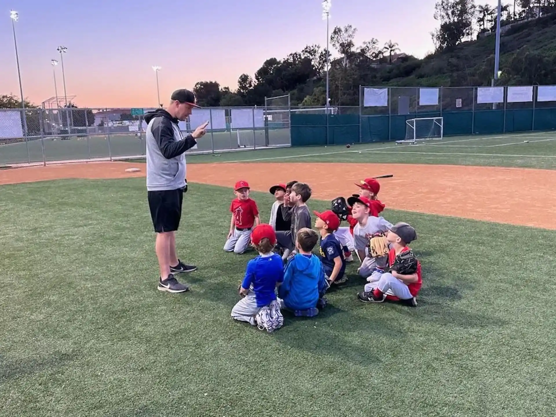 a person standing in front of a group of kids sitting on the ground