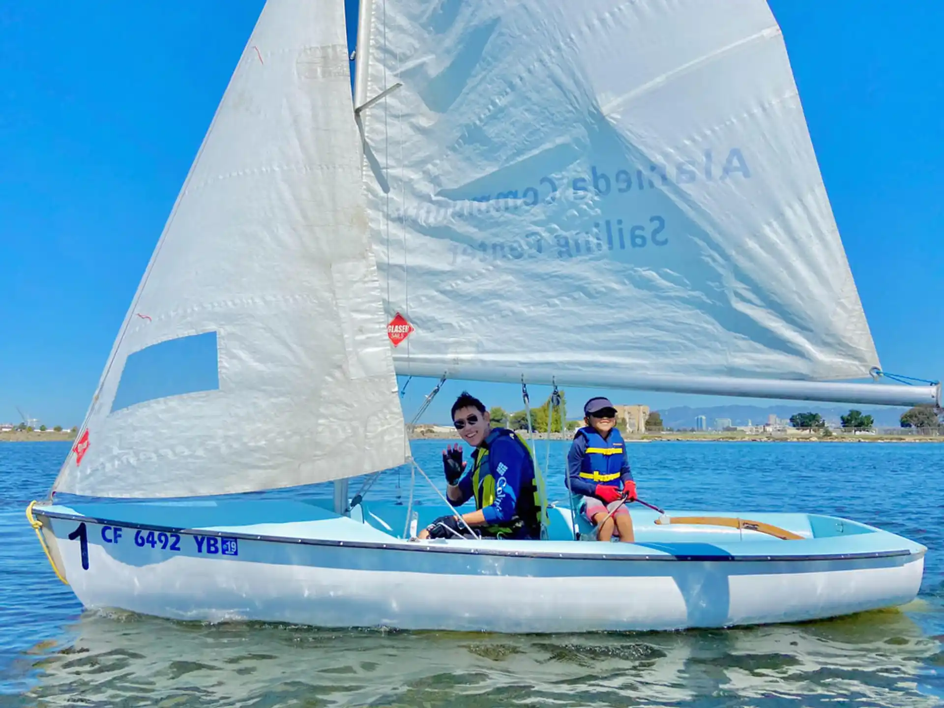 a couple of people on a sailboat in the water