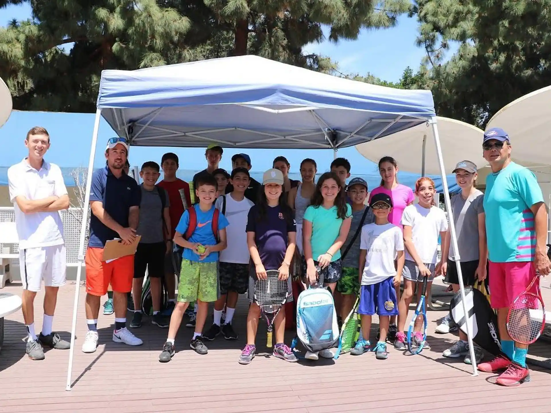 a group of people posing for a photo under a tent