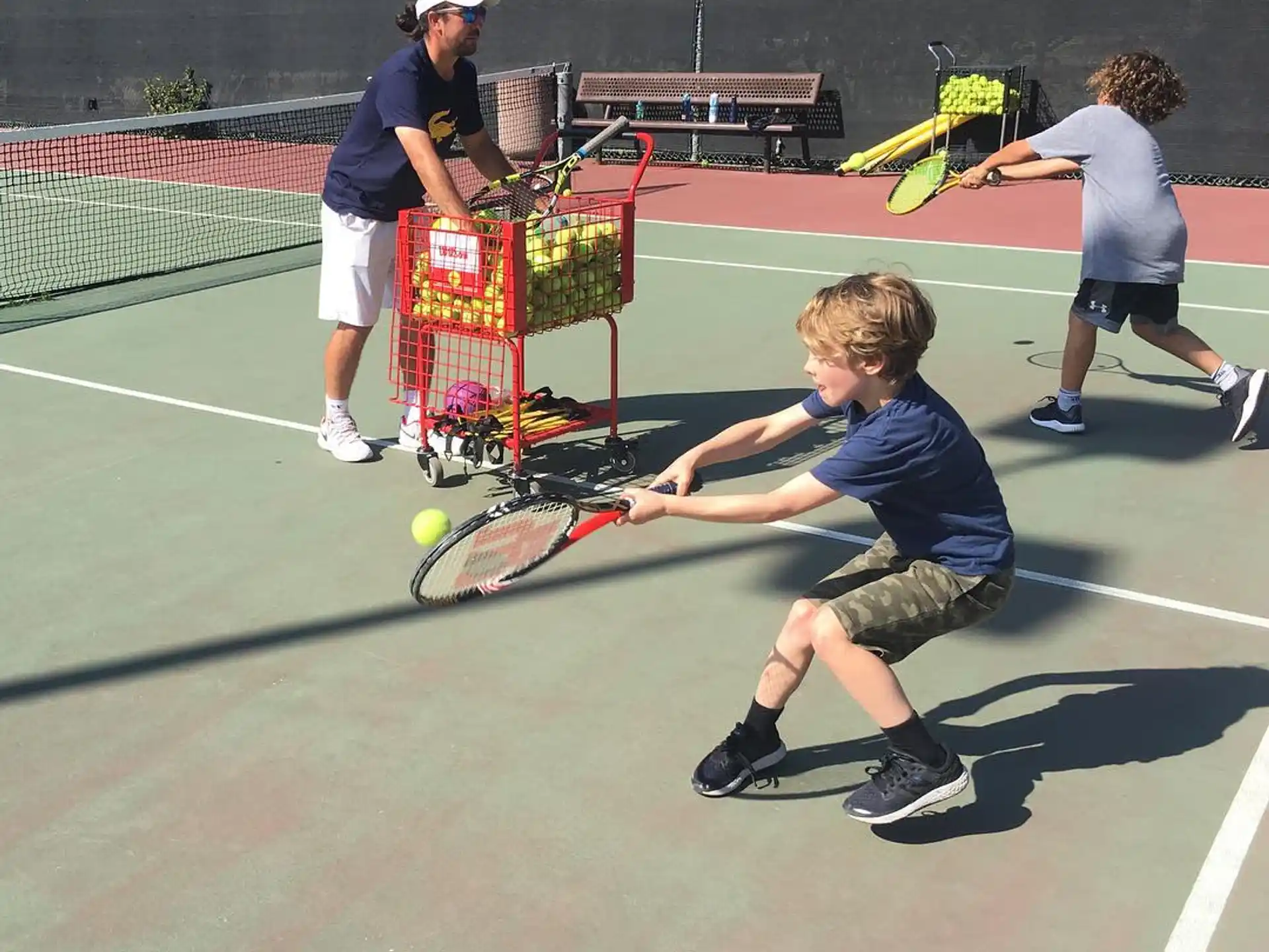 a kid swings a tennis racket