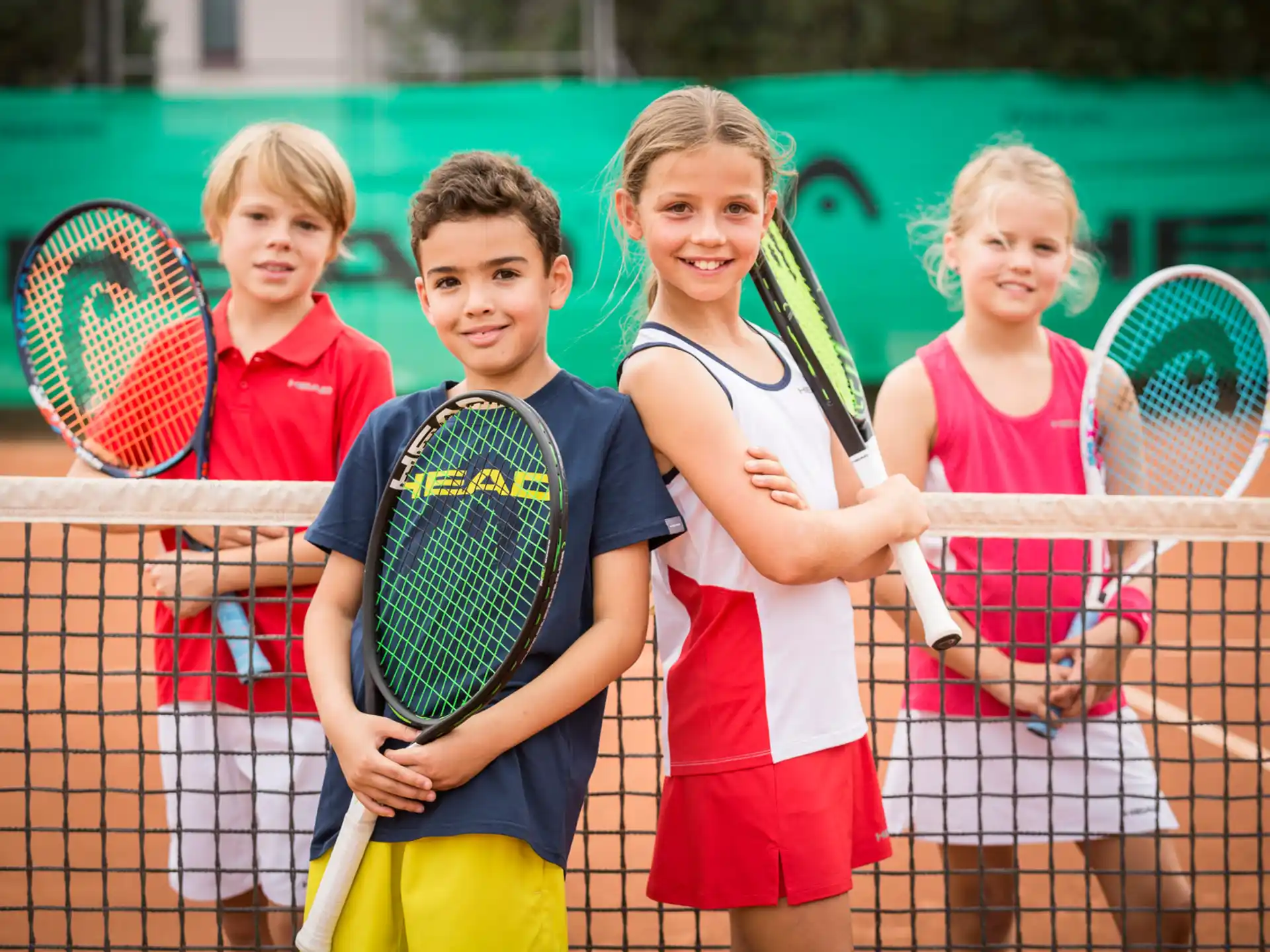a group of kids holding tennis rackets